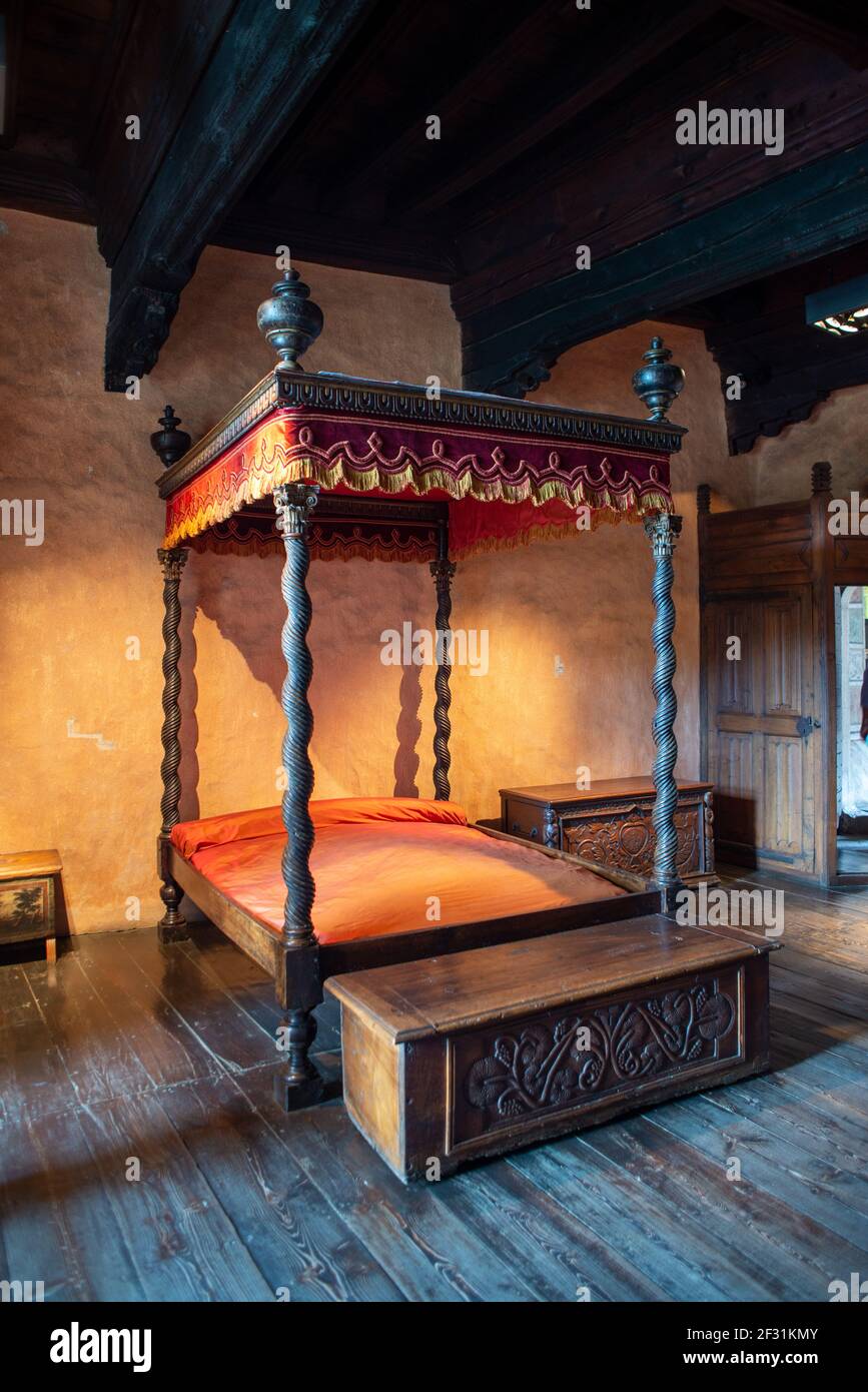 Antico letto a baldacchino in legno in una delle camere da letto del Castello di Fenis, Valle d'Aosta, Italia Foto Stock
