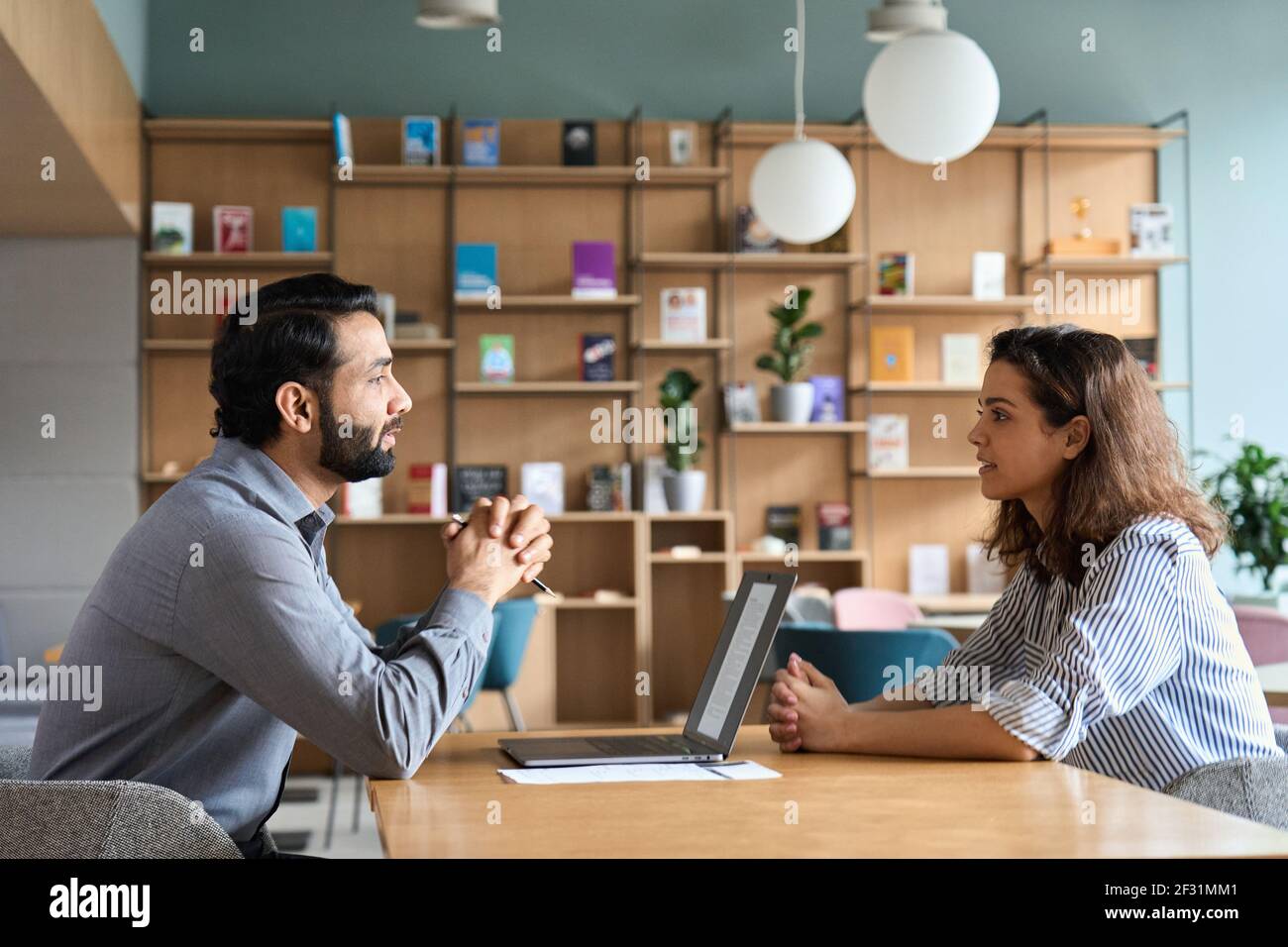 Indiano ora datore di lavoro ascolto latino candidato alla riunione di intervista di lavoro. Foto Stock