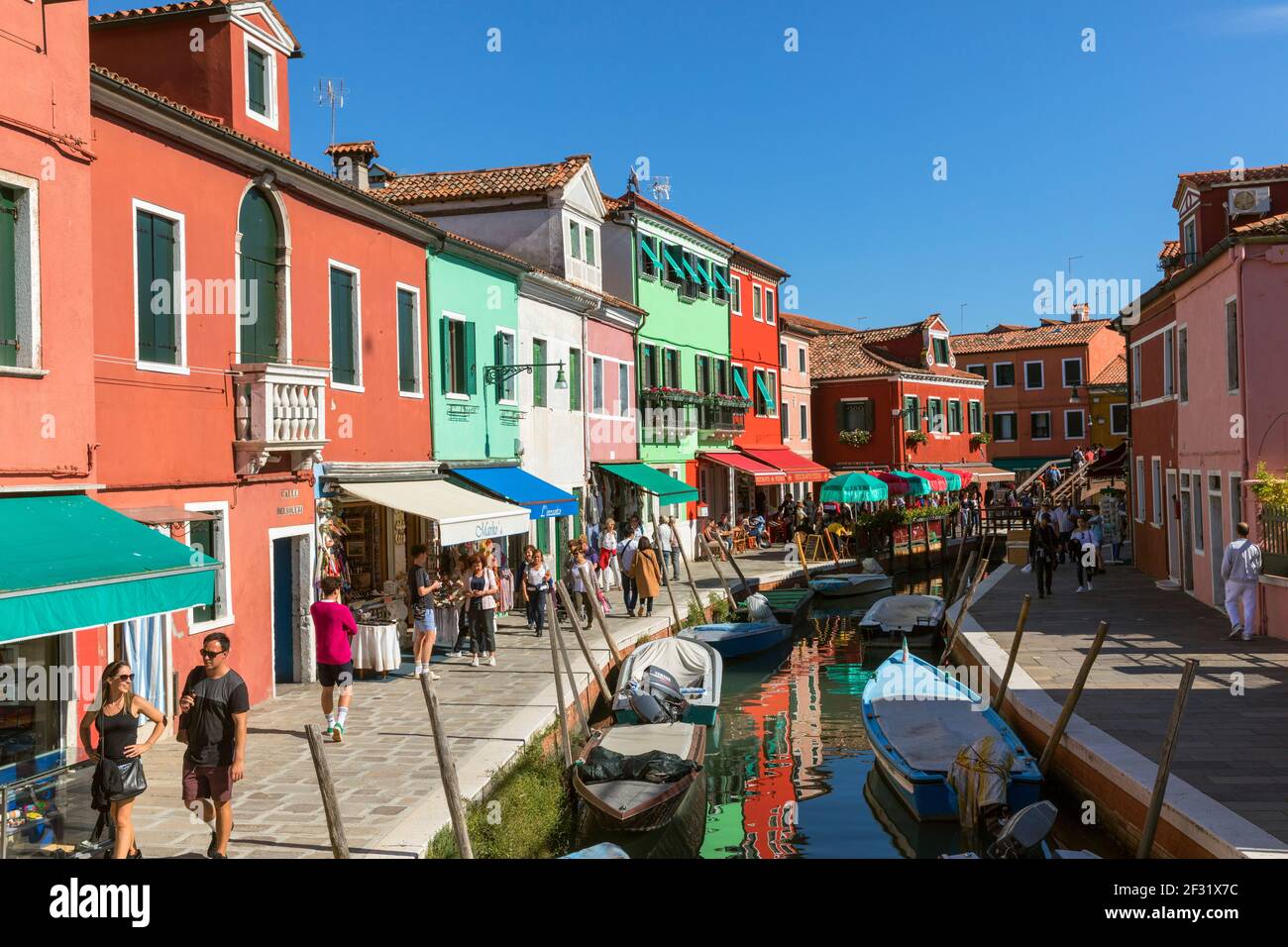 Italia, Venezia, Burano, negozi e ristoranti lungo un canale Foto Stock