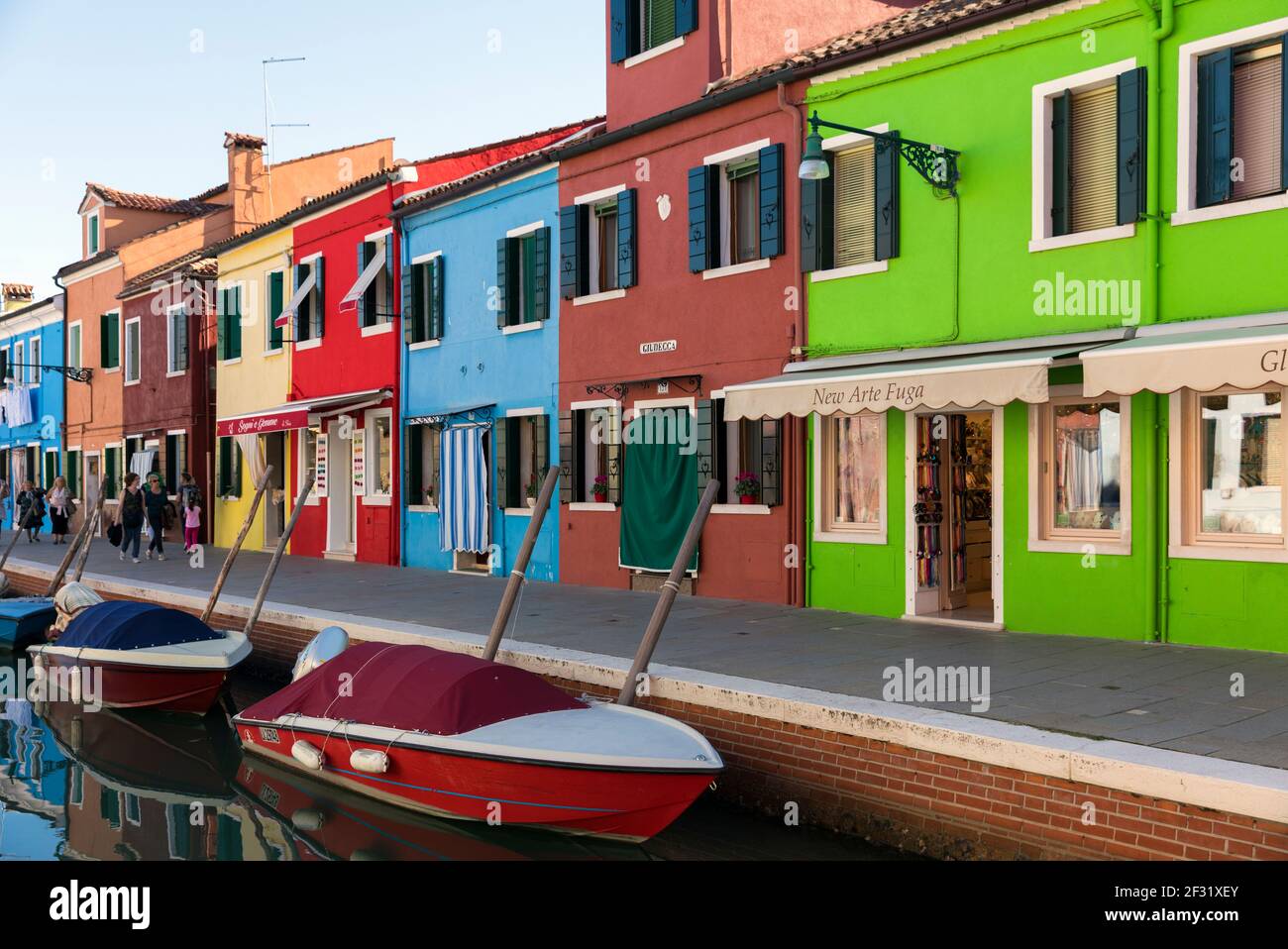 Italia, Venezia, Burano, colorati negozi dipinti che costeggiano un canale Foto Stock