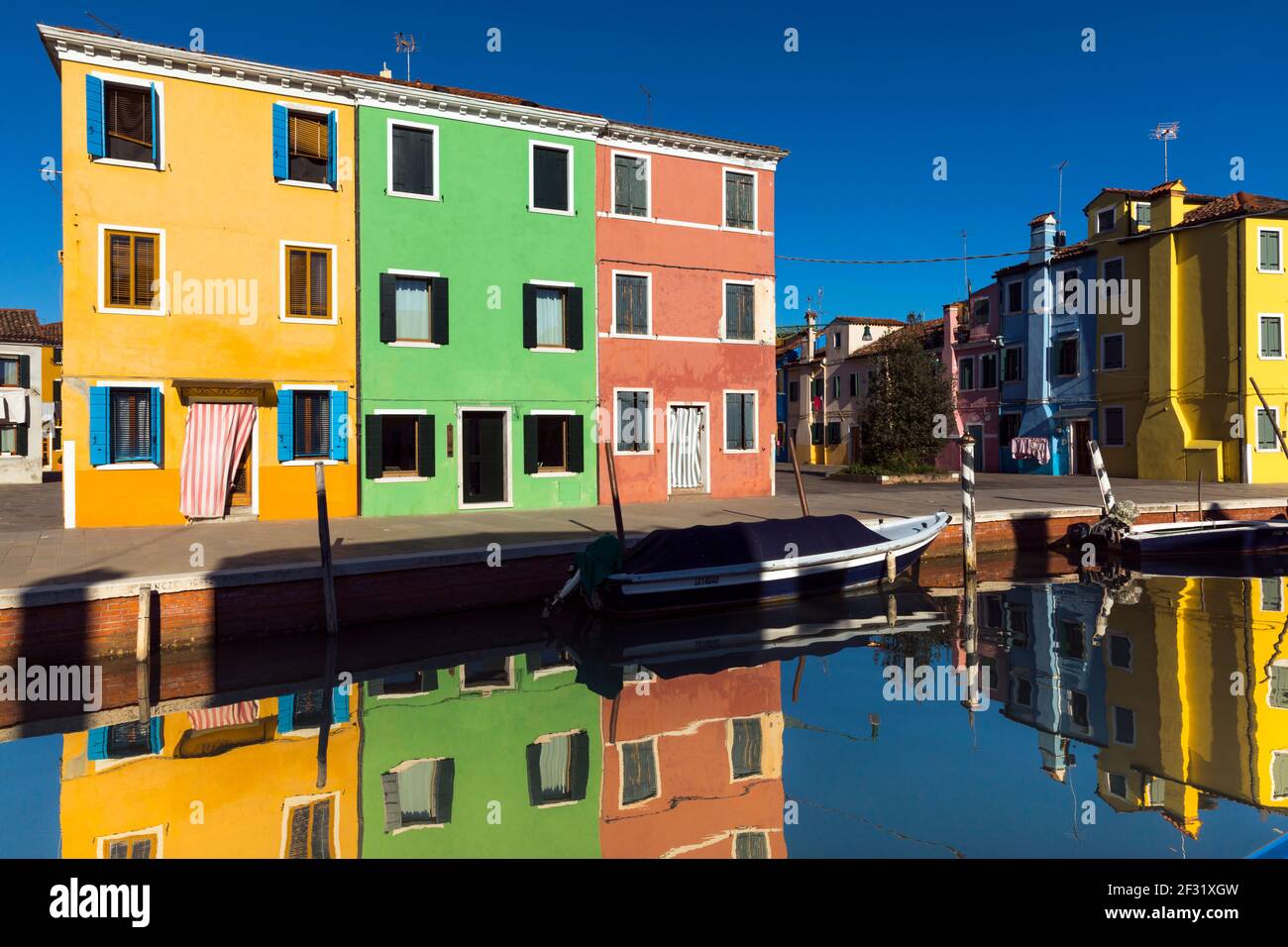 Italia, Burano, casa colorata che si riflette nel canale Foto Stock