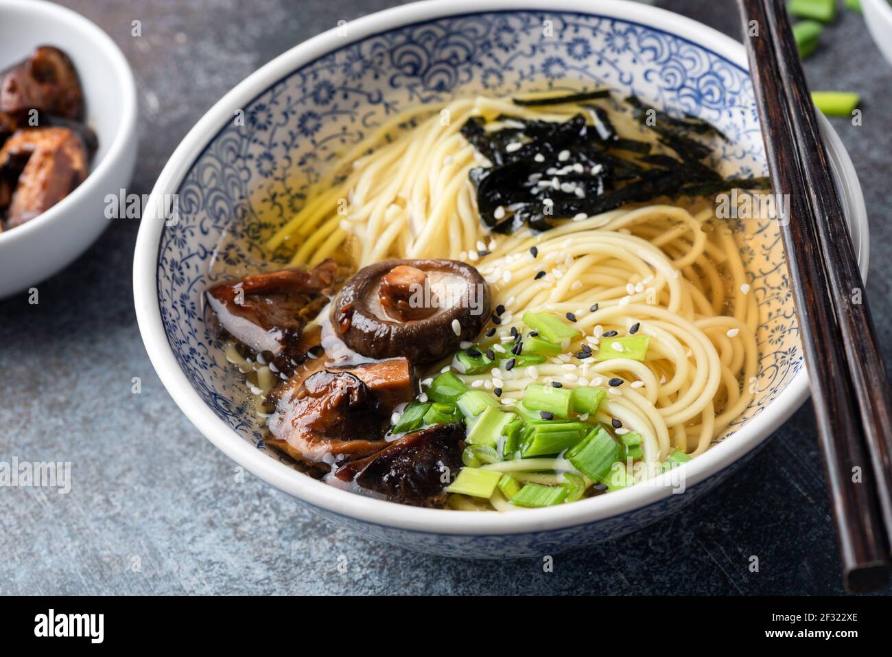 Zuppa asiatica di noodle con funghi shiitake e alghe. Ciotola di ramen vegetariana Foto Stock