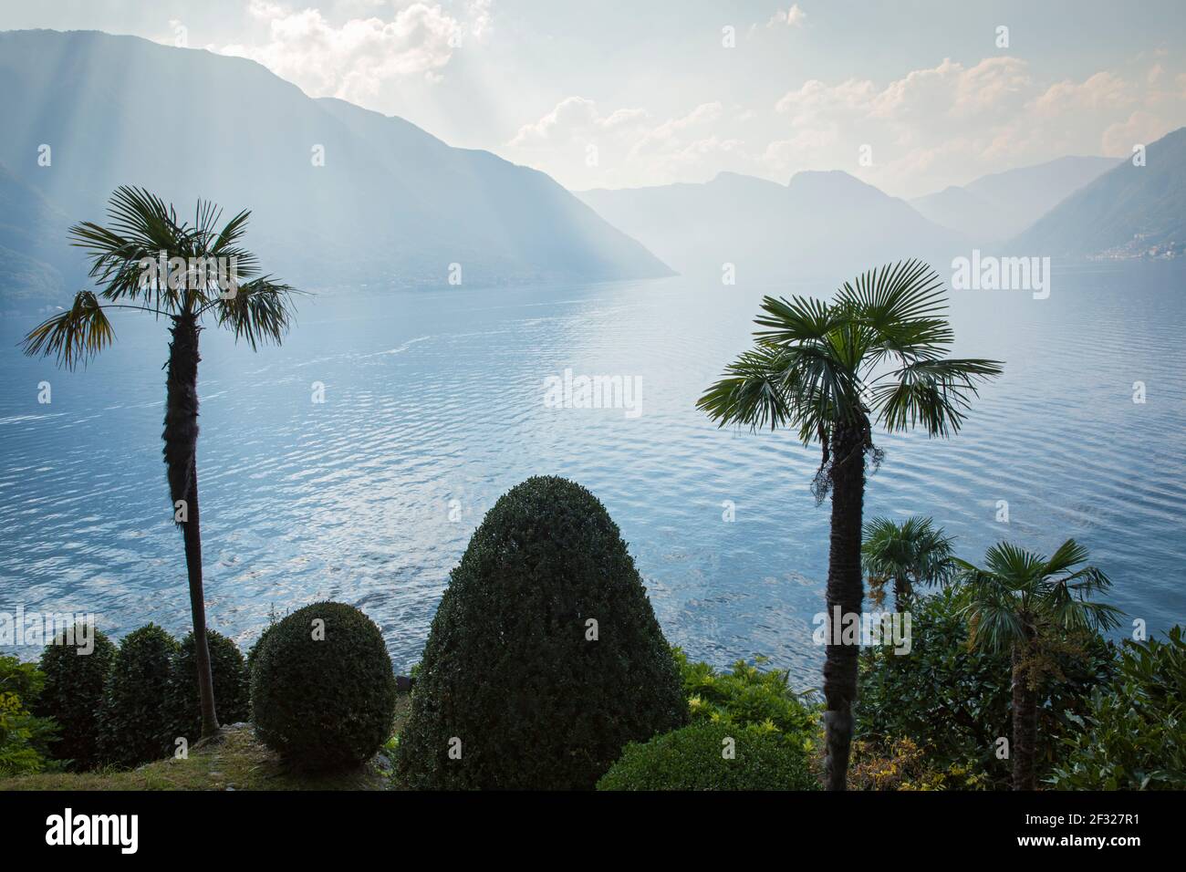 Italia, Lombardia, Lenno, vista sul Lago di Como con montagne e palme da Villa del Balbianello Foto Stock