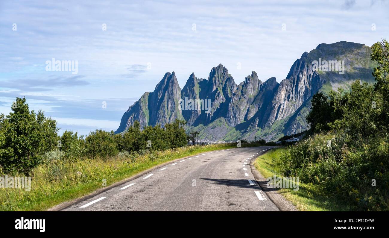 Strada, dietro la cima rocciosa Devil's denti, Okshornan, Isola di Senja, Troms, Norvegia Foto Stock