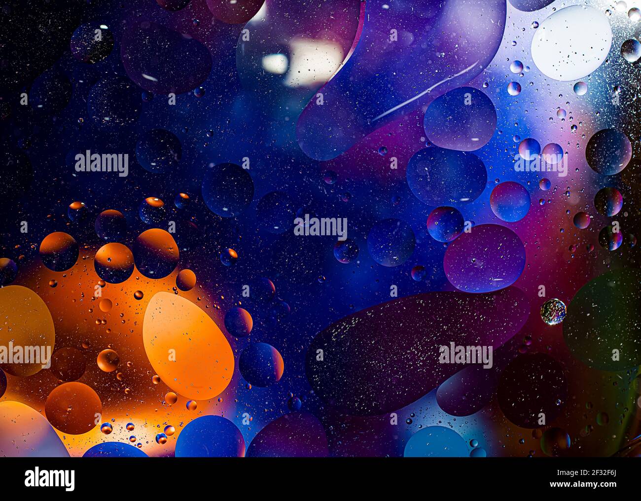 Foto di olio su una superficie d'acqua con bolle. Sfondo colorato astratto. Primo piano della macro, non illustrazione Foto Stock