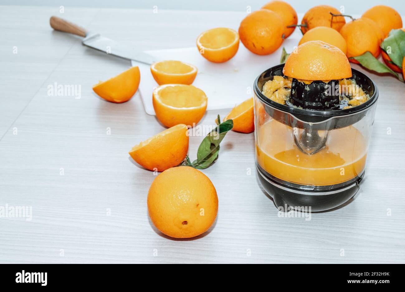 Spremuta d'arancia e frutta fresca d'arance su tavola di legno. Foto Stock