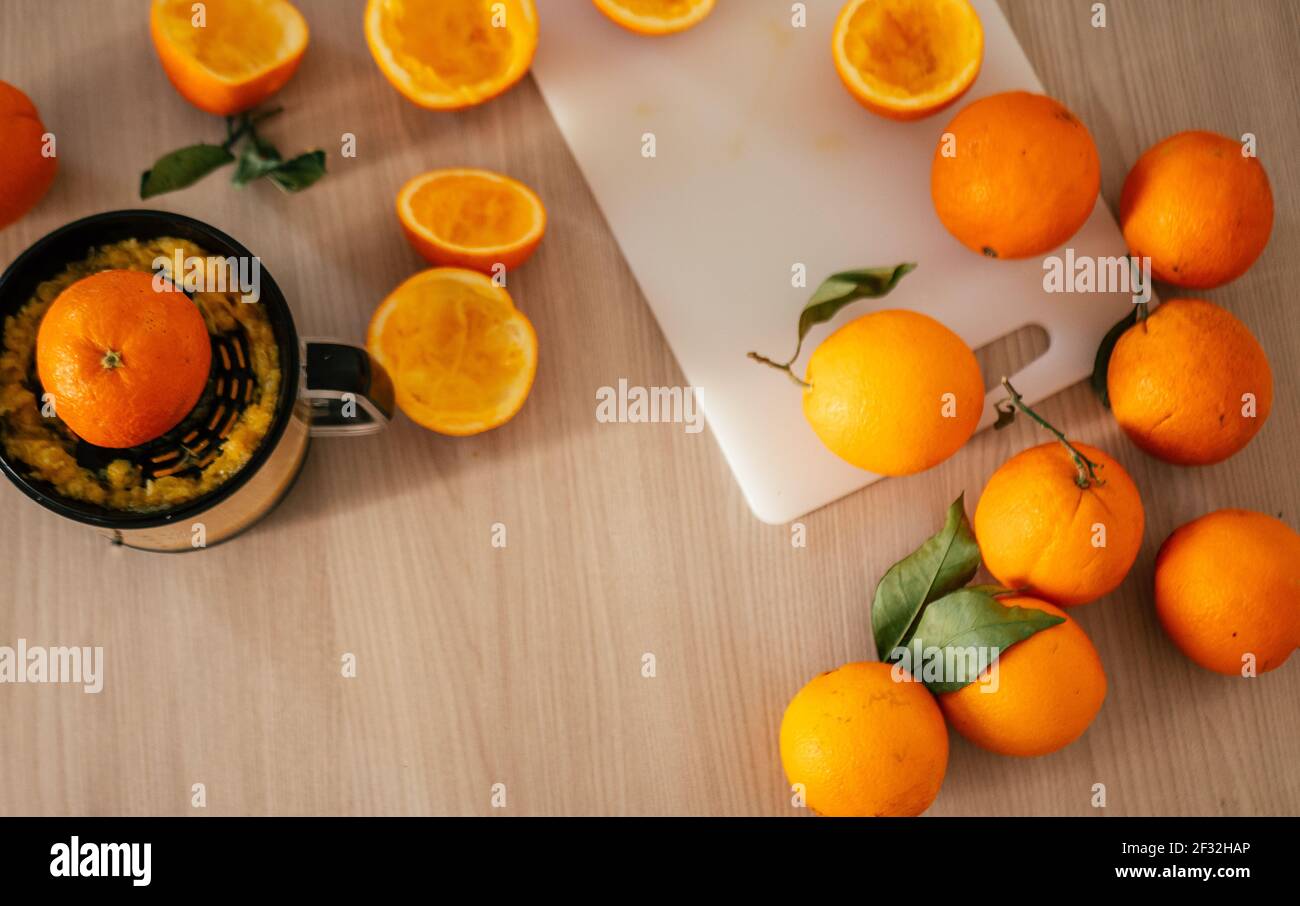 Spremuta d'arancia e frutta fresca d'arance su tavola di legno. Foto Stock
