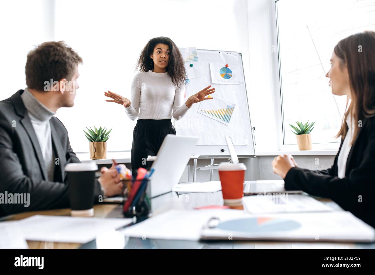 Grave capo di azienda femminile che fa una presentazione sul profitto di azienda ai dipendenti. Giovane donna d'affari influente ed elegante che parla di rapporti finanziari sulla riunione di briefing, concetto di conferenza Foto Stock