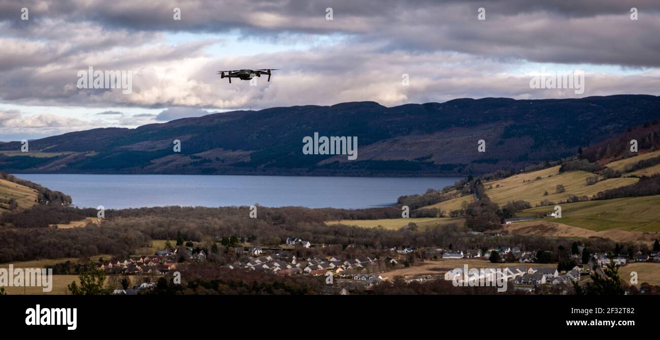 Un piccolo drone DJI passa sopra Drumadrochit e Lochness Foto Stock