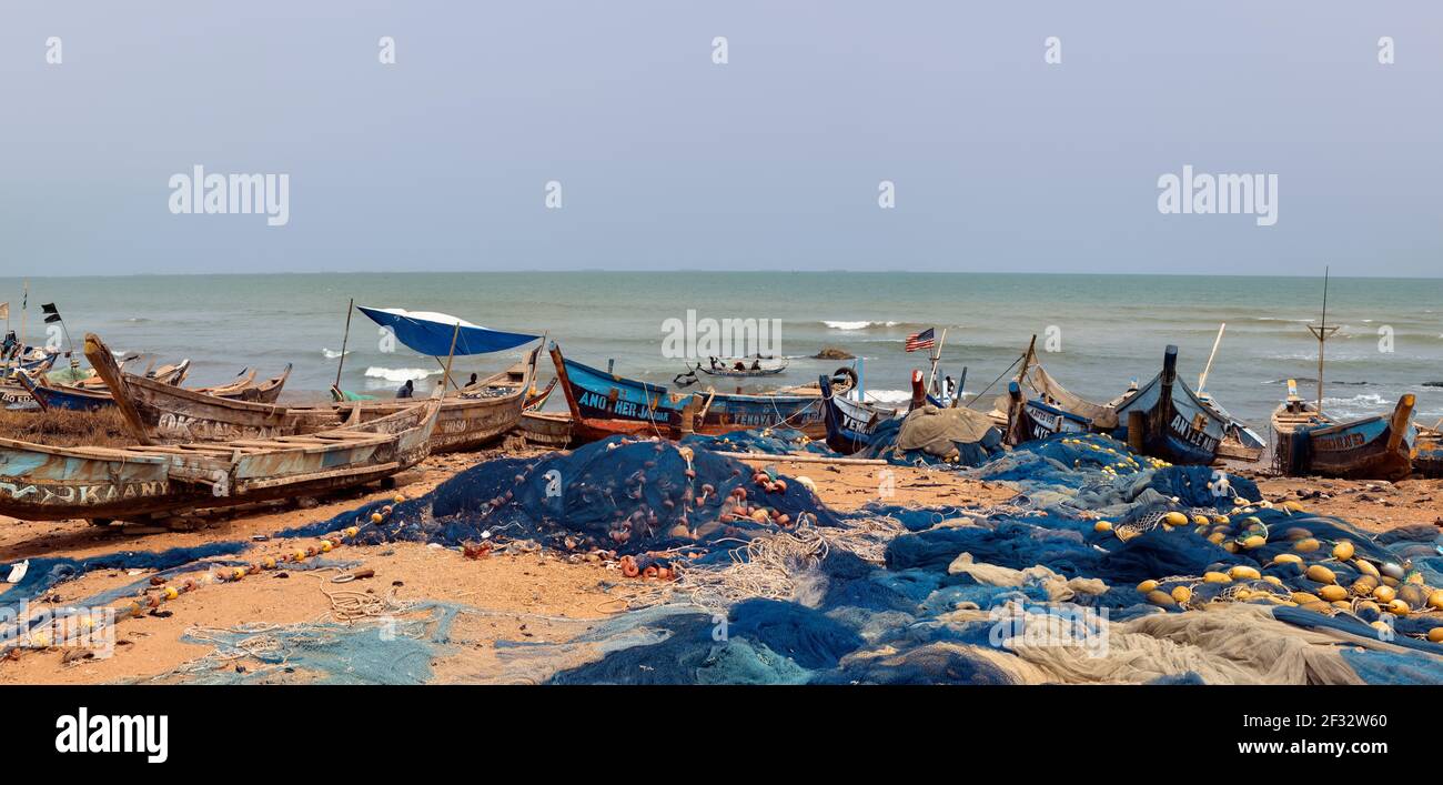 Villaggio di pescatori spiaggia vicino Accra Ghana. Vecchie barche da pesca fatte a mano. Imbarcazioni costruite a mano. Servizi igienico-sanitari scadenti, quartieri poveri. Foto Stock