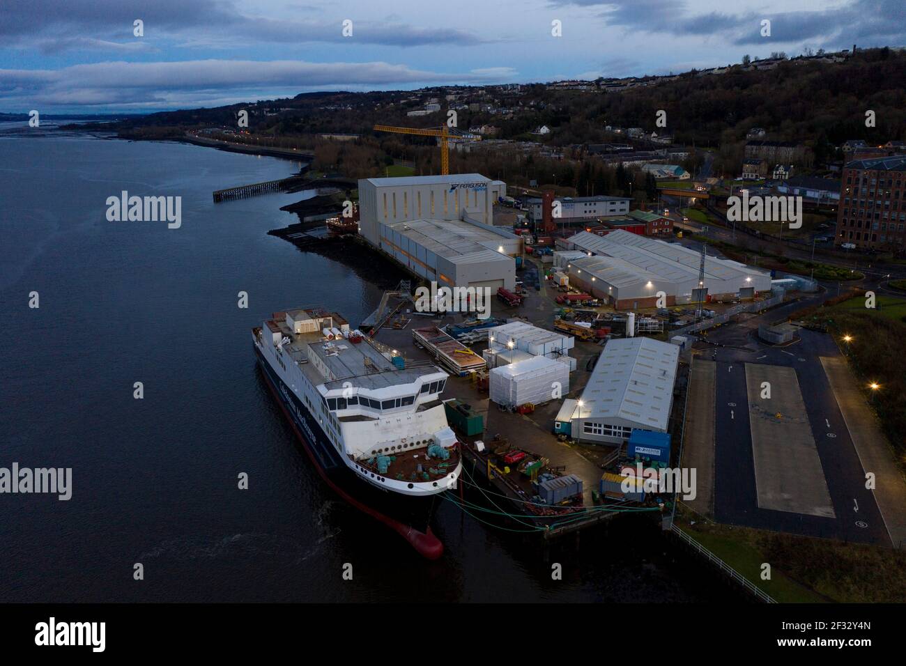 Port Glasgow, Scozia, Regno Unito. 14 Marzo 2021. Nella foto: Drone fotografia aerea vista del Caledonian MacBrayne (CalMac) traghetto di nome Glen Sannox, galleggia nel Firth di Clyde ancora in fase di fabbricazione. L'attuale progetto di proprietà del governo scozzese è in ritardo, ma dovrebbe essere consegnato a Caledonian MacBrayne entro il prossimo anno. Gli arresti COVID19 hanno aggiunto un costo aggiuntivo di £4,3 milioni ai costi già sovraprevisti per i traghetti. Credit: Colin Fisher/Alamy Live News Foto Stock