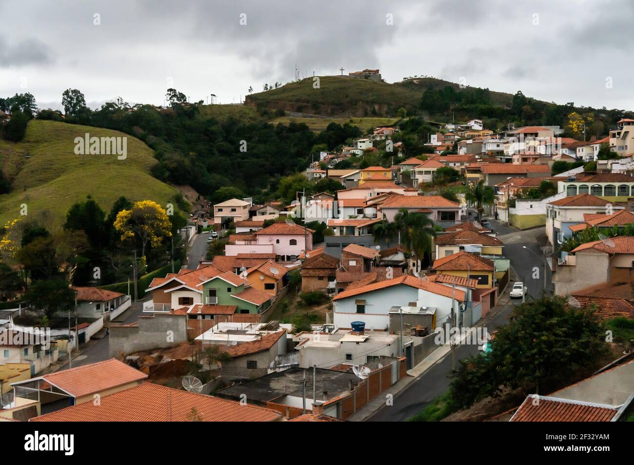 Vista sud-est della zona residenziale su una zona collinare del comune di Cunha nel tardo pomeriggio e sotto il cielo sovrastato. Foto Stock