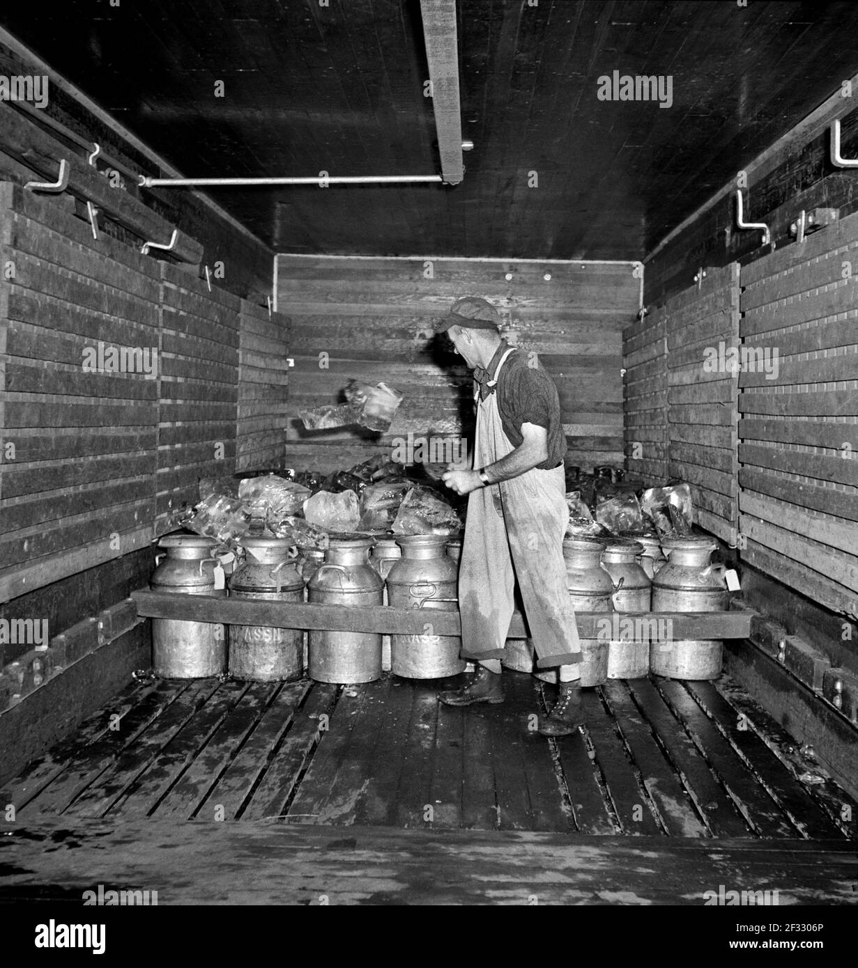 Operaio che tovola il ghiaccio nel carico ferroviario del latte, Creamery cooperativa degli agricoltori Uniti, Sheldon Springs, Vermont, USA, Jack Delano, U.S. Farm Security Administration, settembre 1941 Foto Stock