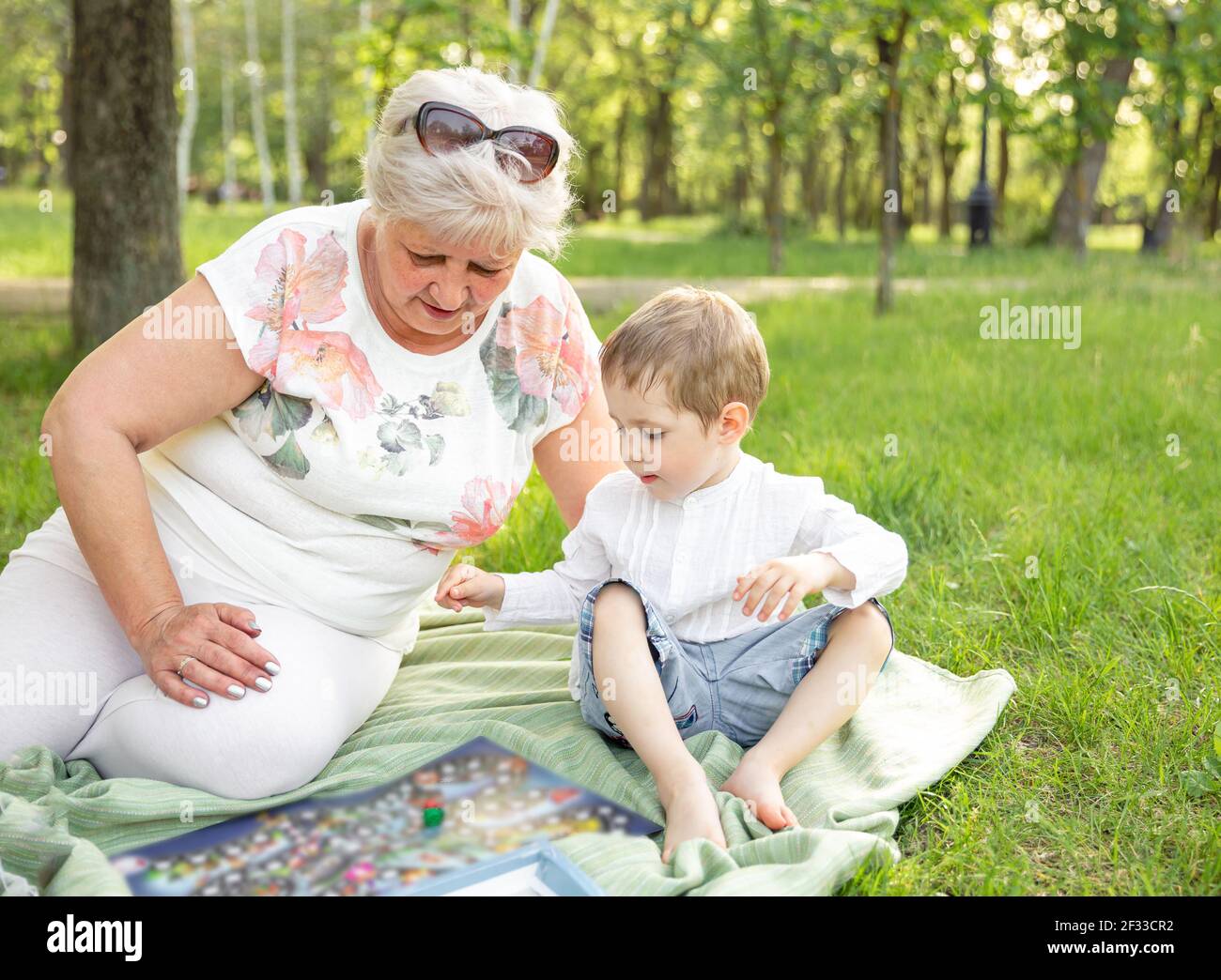La famiglia gioca nella foresta estiva. Momenti felici con la nonna Foto Stock