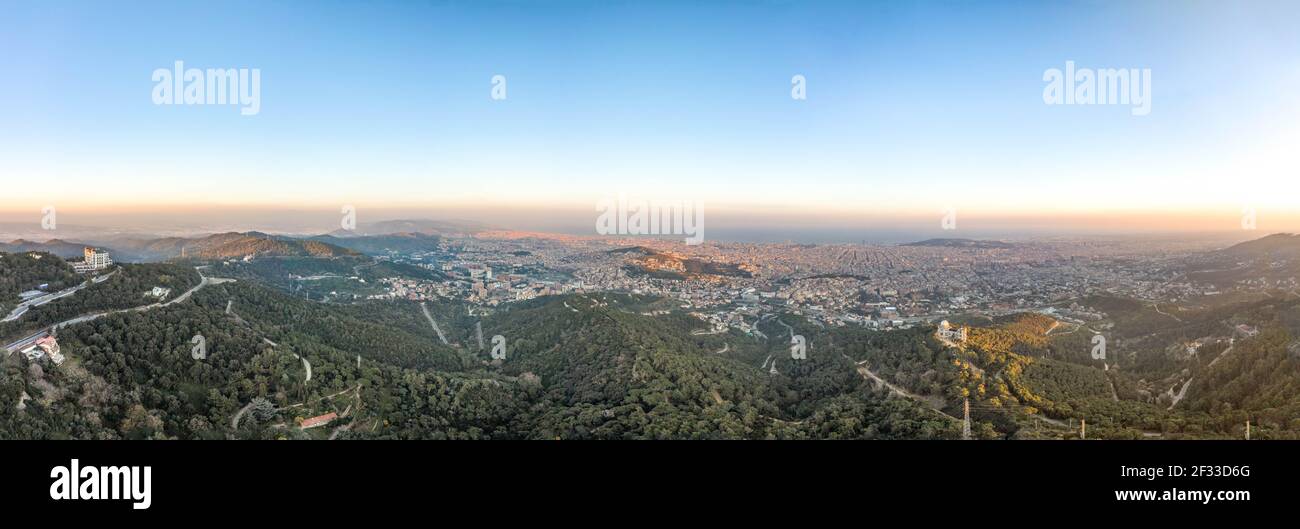 Panorama Aerial drone shot del Monte Tibidabo con vista sulla città Di Barcellona durante il tramonto Foto Stock