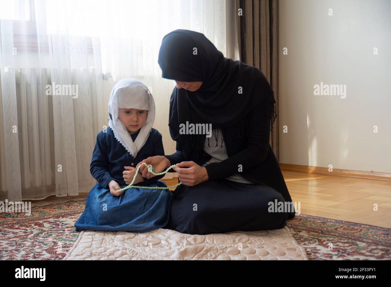 La bambina e la madre si guardano a vicenda. Donna hijab e sua figlia. Aiuto mubarak. musulmano Foto Stock