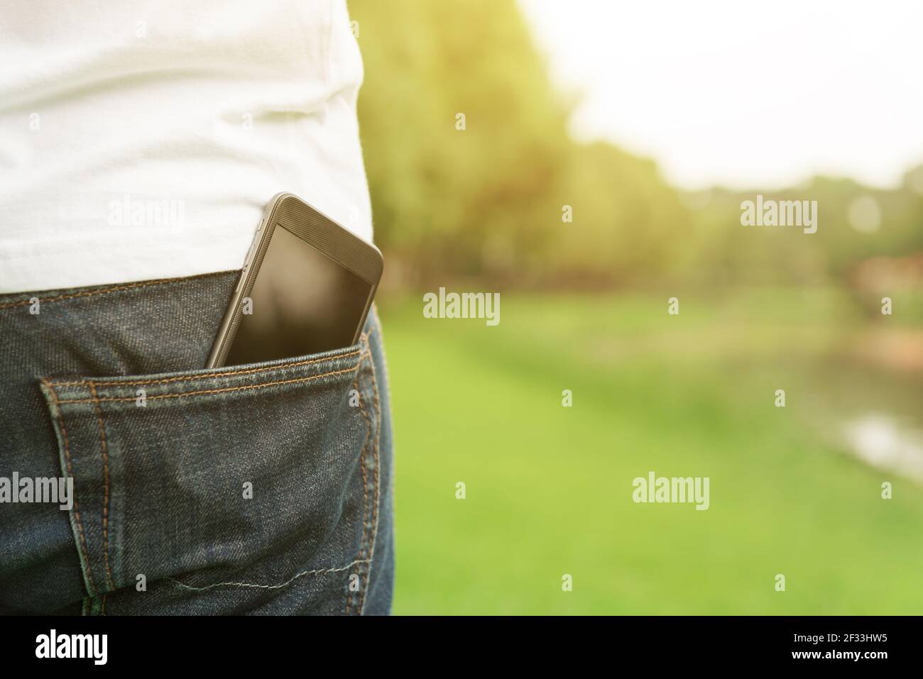 Smartphone nella tasca posteriore dei jeans di un uomo Foto Stock