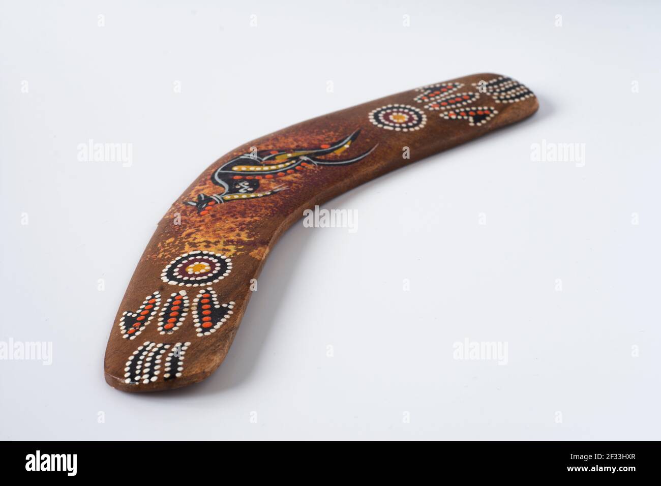 Souvenir australiano, boomerang colorato e ornato. Fuoco selettivo. Sfondo bianco isolato. Foto Stock