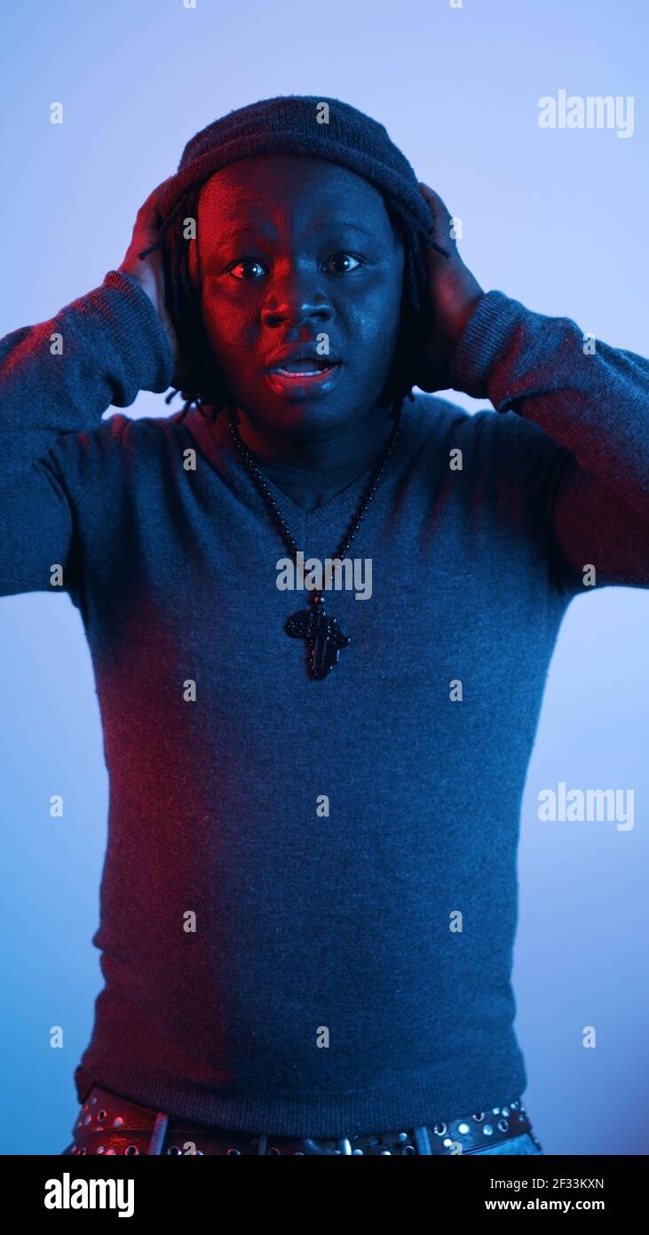 Uomo nero afroamericano che ricopre le orecchie con le mani. Foto di alta qualità Foto Stock
