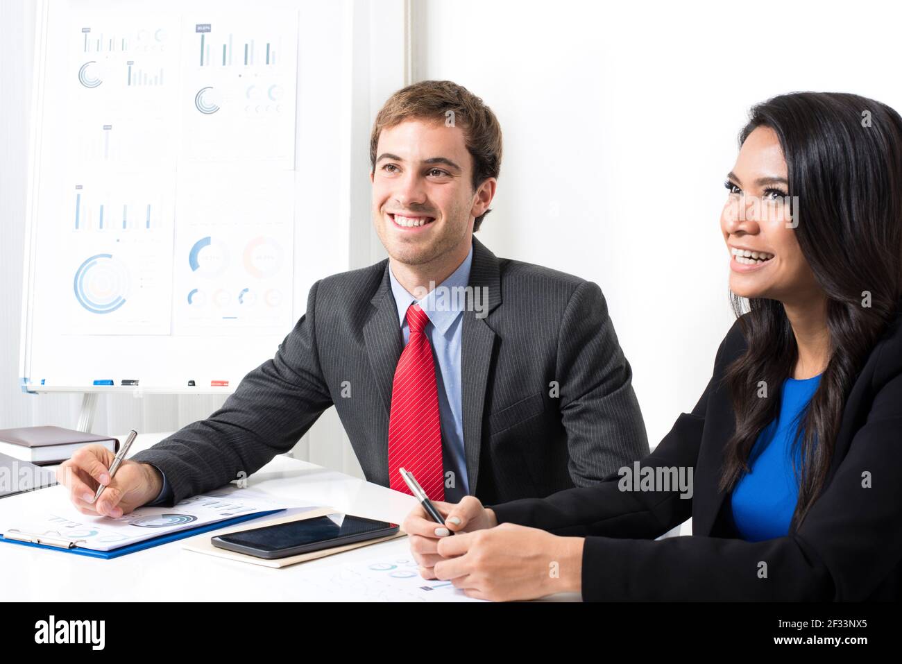 Sorridente gente di affari di corsa mista nella sala riunioni Foto Stock