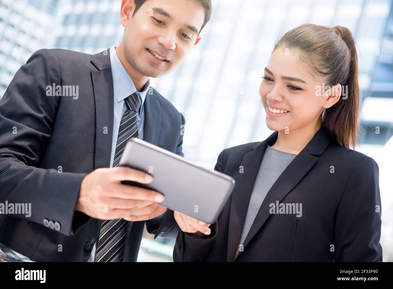Uomo d'affari e uomo d'affari che guarda al tablet pc, che discute di lavoro Foto Stock
