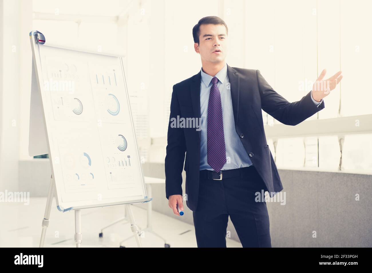Giovane uomo d'affari come un leader di riunione che presenta il suo lavoro, effetto tono vintage Foto Stock