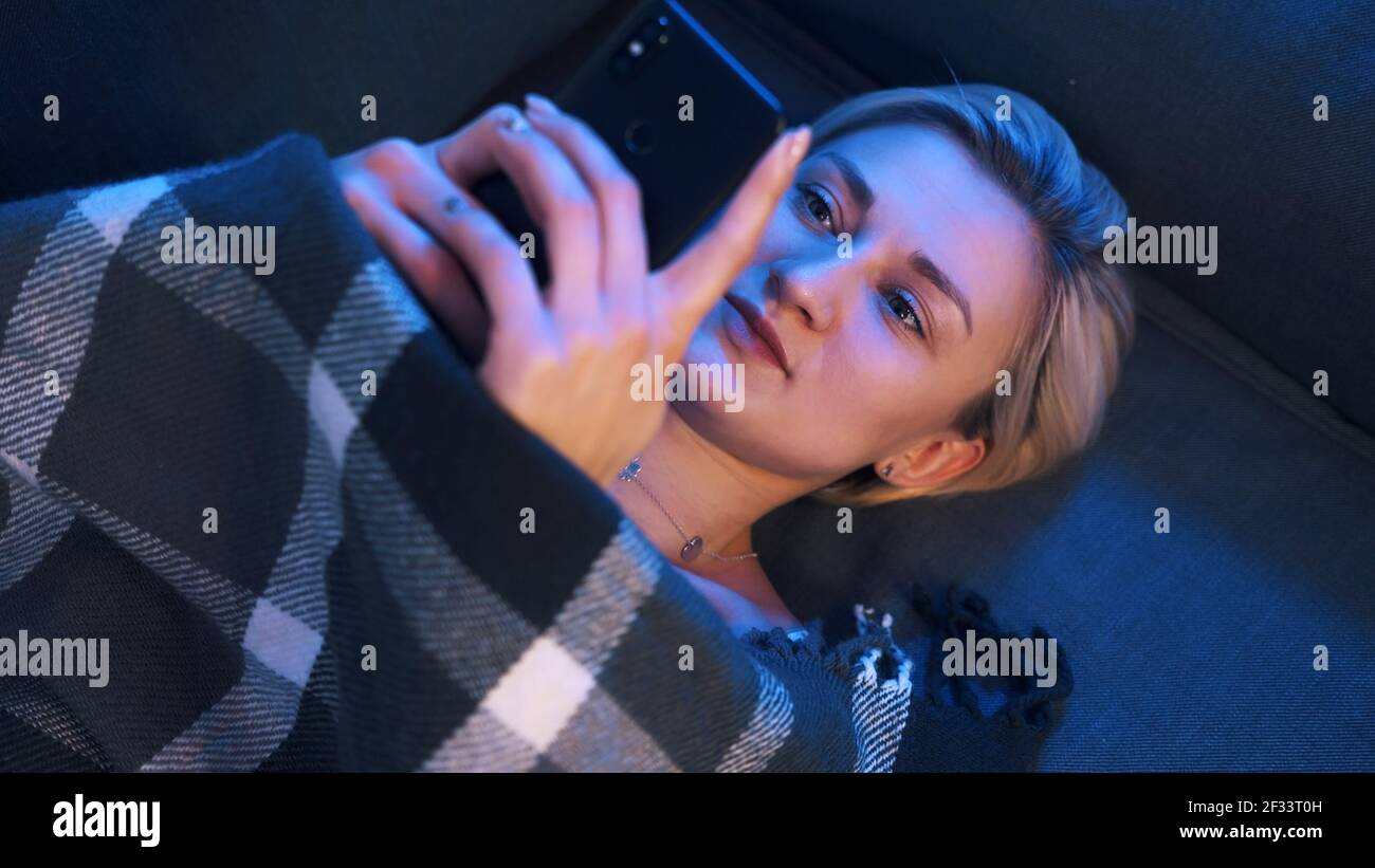 Giovane donna sola impostazione del profilo di datazione utilizzando lo smartphone. Datazione quarantena. Foto di alta qualità Foto Stock