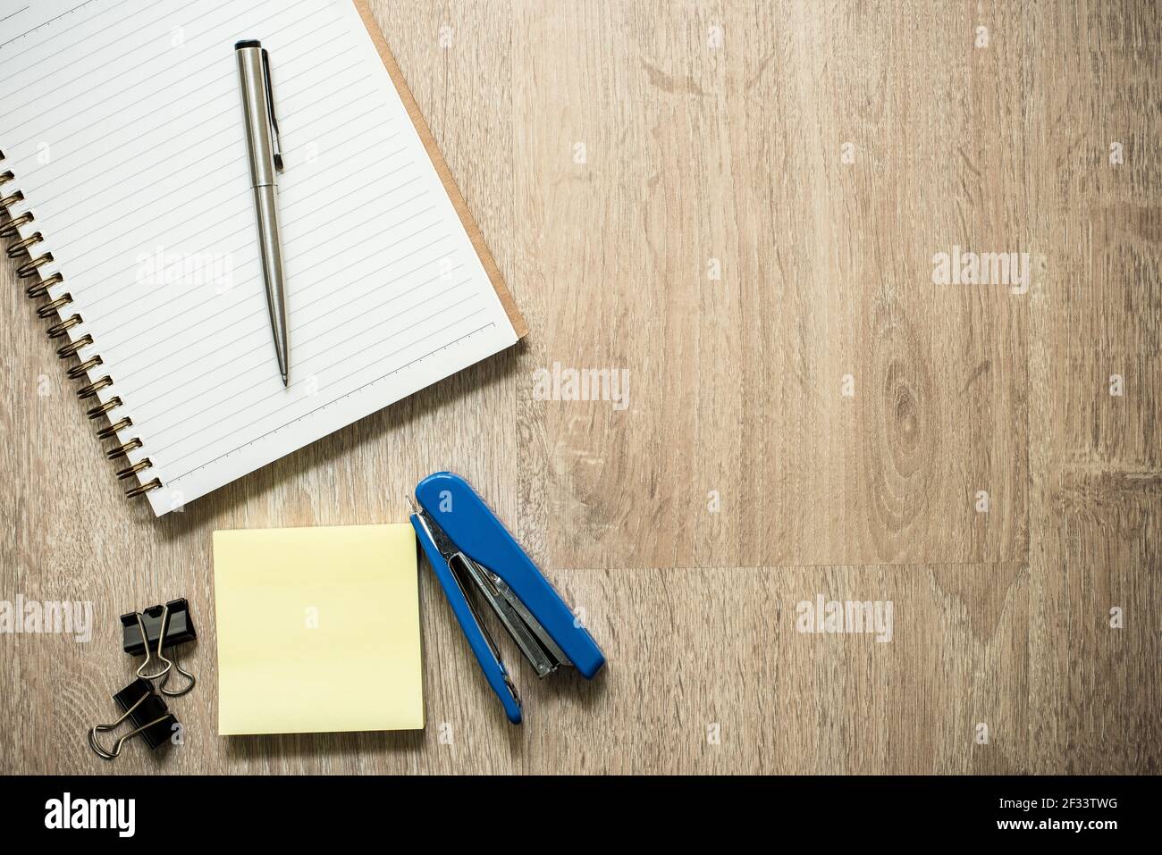 Notebook con articoli di cancelleria per ufficio su sfondo in legno, vista dall'alto (disposizione piatta) con spazio per la copia Foto Stock