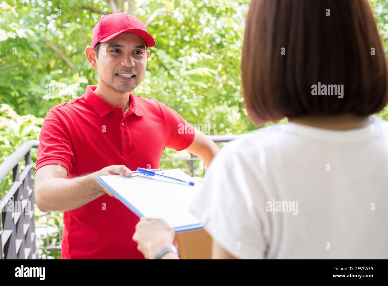 Consegna uomo che dà appunti a una donna per firmare Foto Stock