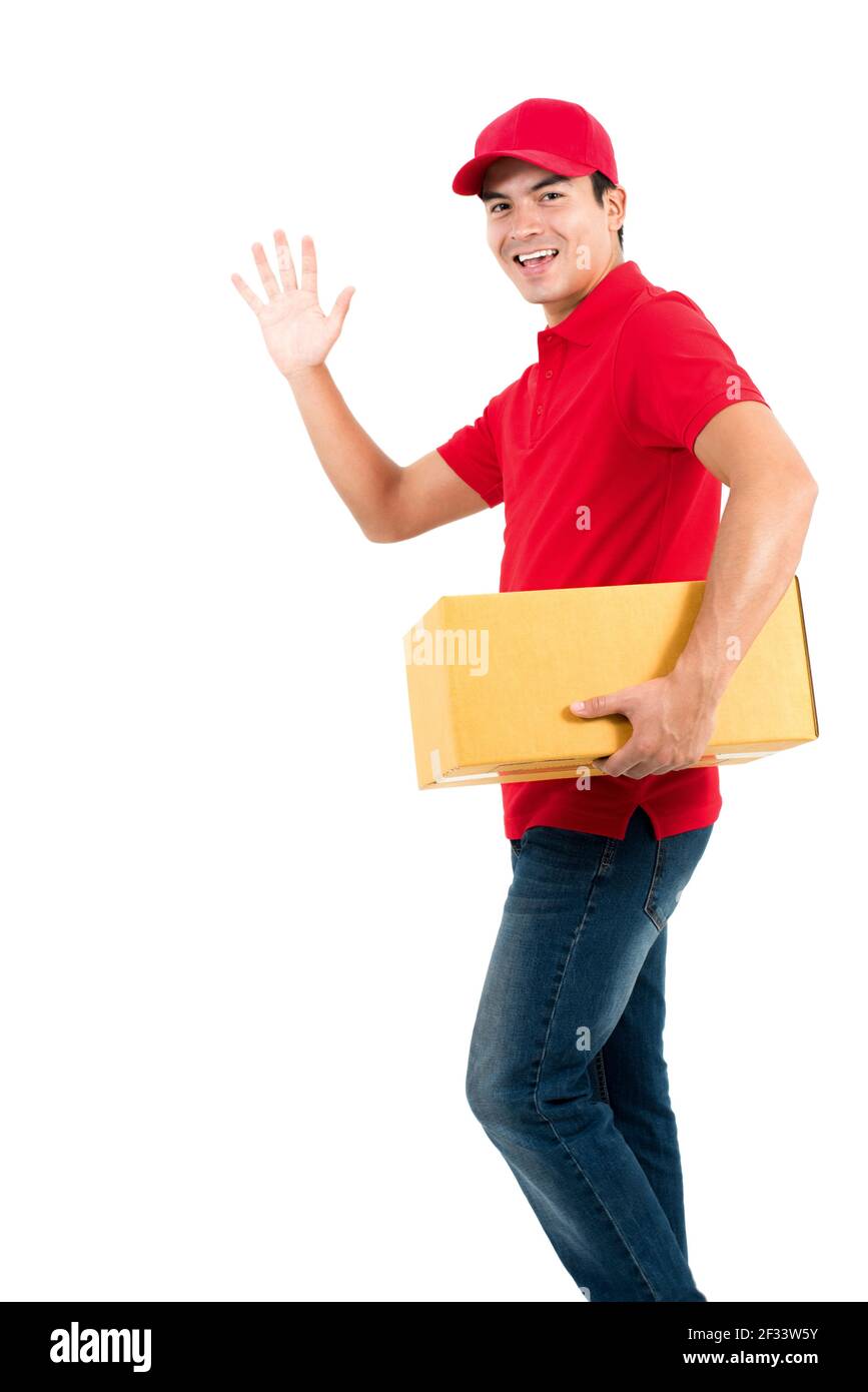 Sorridente delivery man che fa ciao (o arrivederci) gesto mentre si tiene la scatola in un'altra mano - isolato sopra sfondo bianco Foto Stock