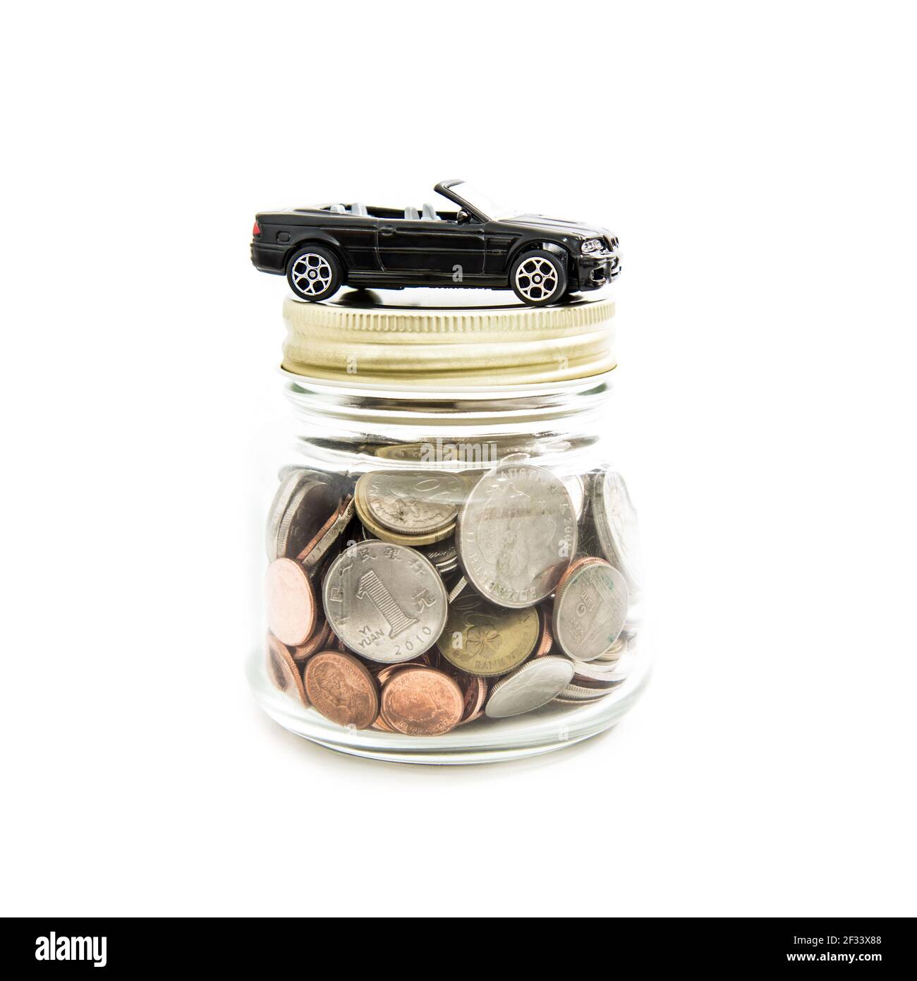Auto giocattolo sul vaso di vetro pieno di denaro (monete) - concetto finanziario automatico Foto Stock