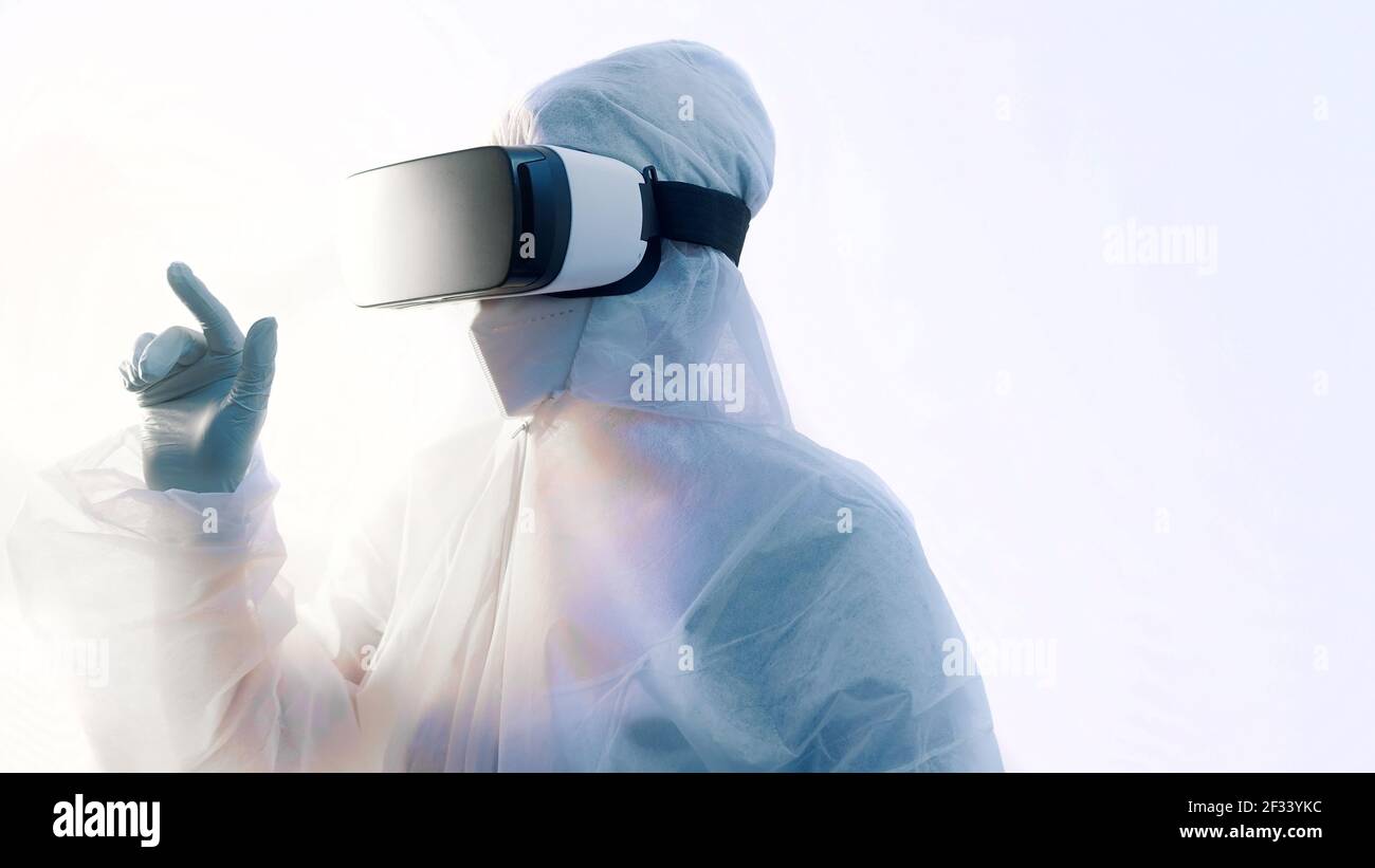 Laboratorio futuristico. Dottore in tuta protettiva con occhiali VR che eseguono ricerche nella simulazione della realtà virtuale. Foto di alta qualità Foto Stock