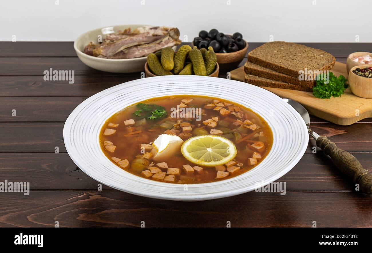 Il piatto con la zuppa tradizionale russa o dell'Europa orientale solyanka o soljanka dal tavolo. Cucina casalinga. Foto Stock