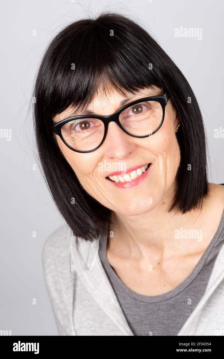 Donna caucasica matura che indossa occhiali sorridenti. Foto Stock