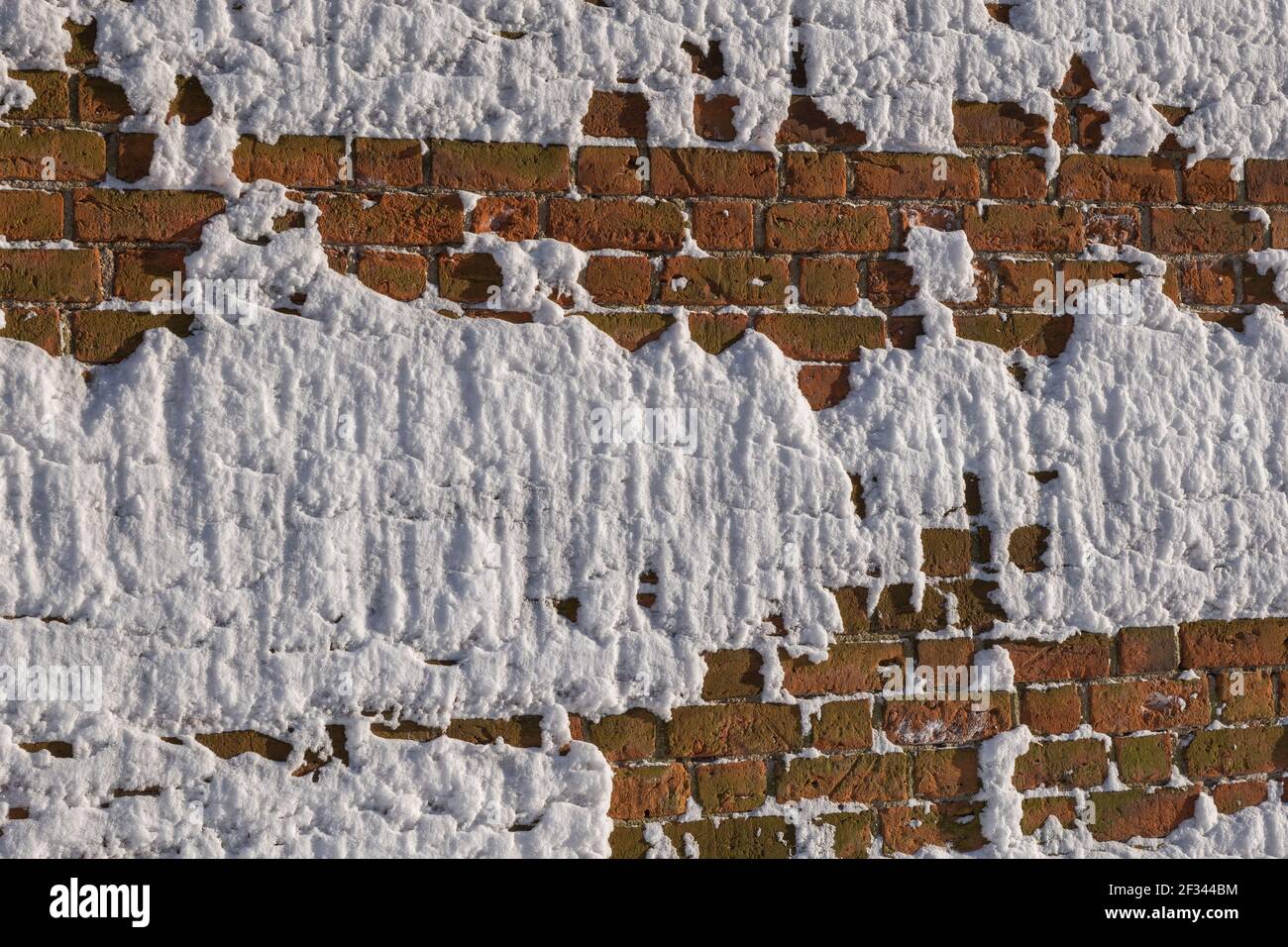 Surgelato neve coperta muro di mattoni fortificazione astratto sfondo invernale Foto Stock