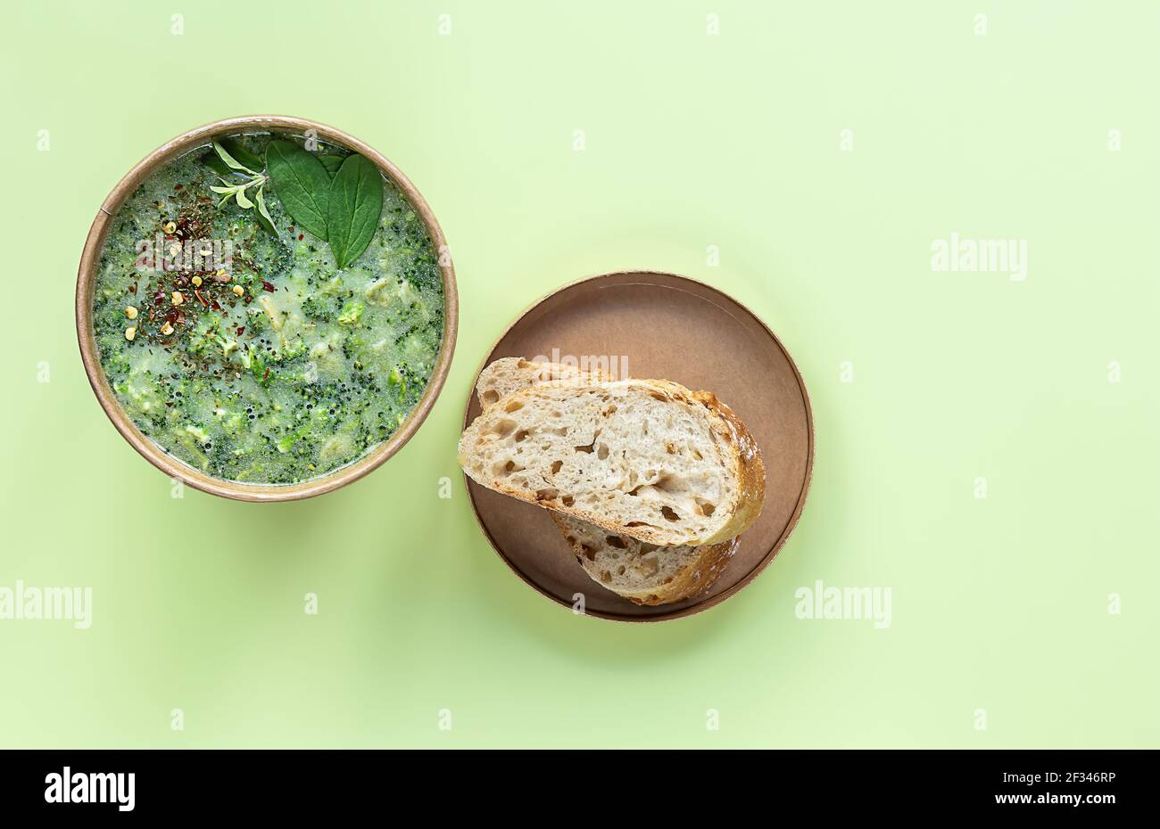 Zuppa di crema di broccoli fresca servita pane fresco e spezie in contenitore artigianale. Pranzo vegetariano da andare. Foto Stock