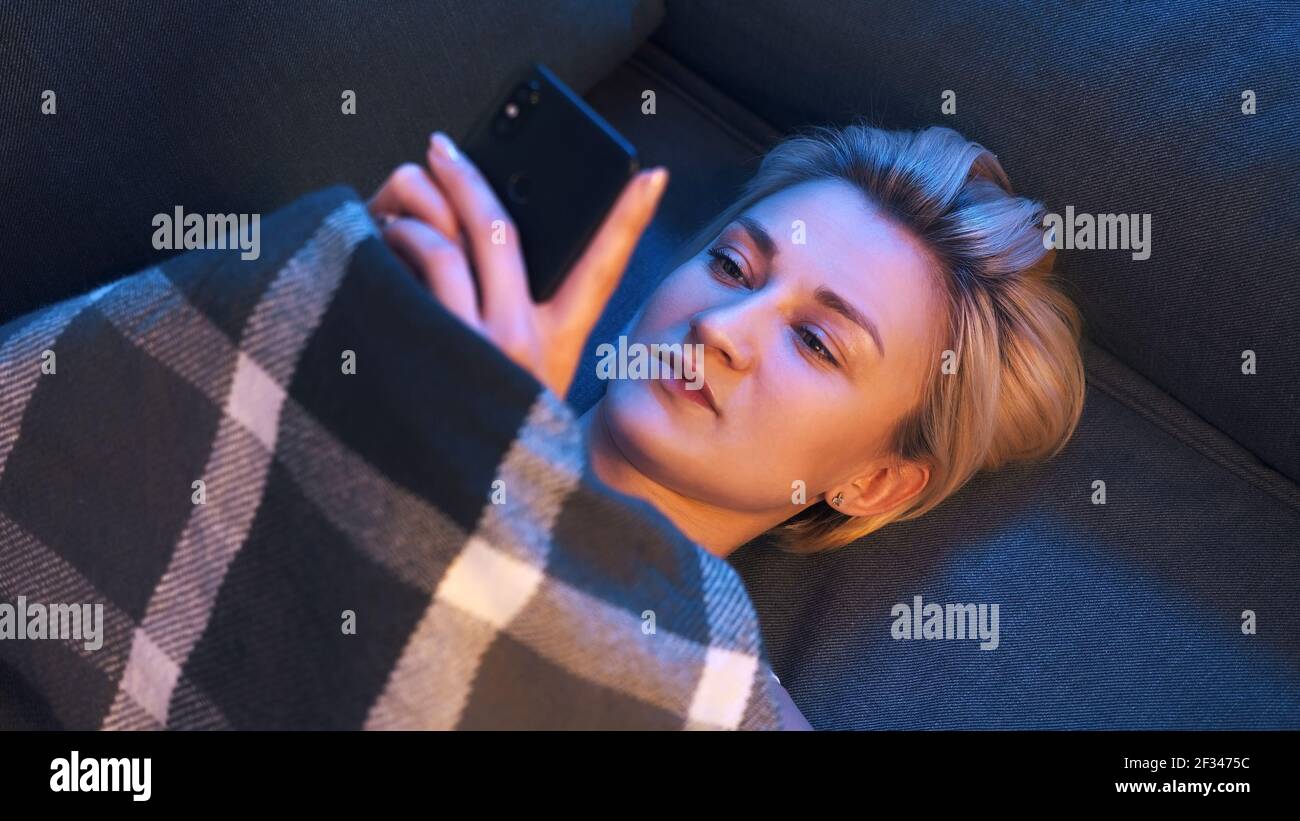 Giovane donna sola impostazione del profilo di datazione utilizzando lo smartphone. Datazione quarantena. Foto di alta qualità Foto Stock