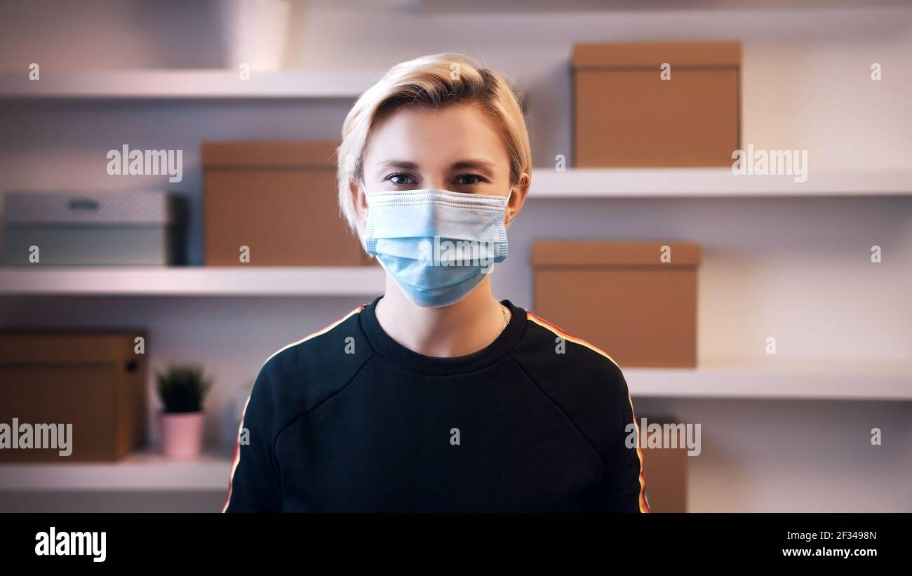 Ritratto di giovane bionda caucasica con maschera medica sopra il viso. Foto di alta qualità Foto Stock