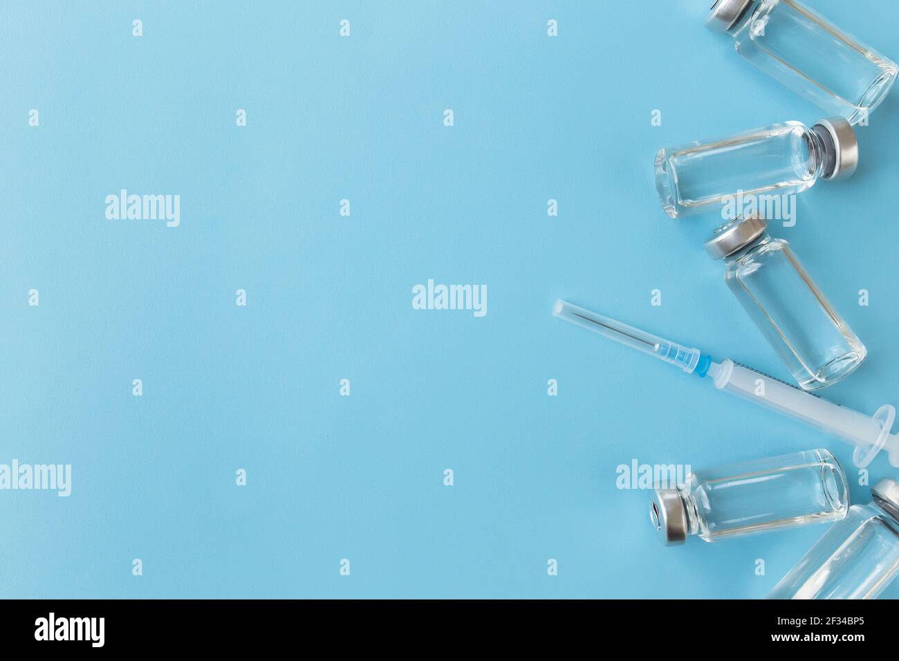 Trattamento medico, concetto di vaccinazione. Flaconi con vaccino, antibiotico, iniezione, siringa su sfondo blu. Foto di alta qualità Foto Stock