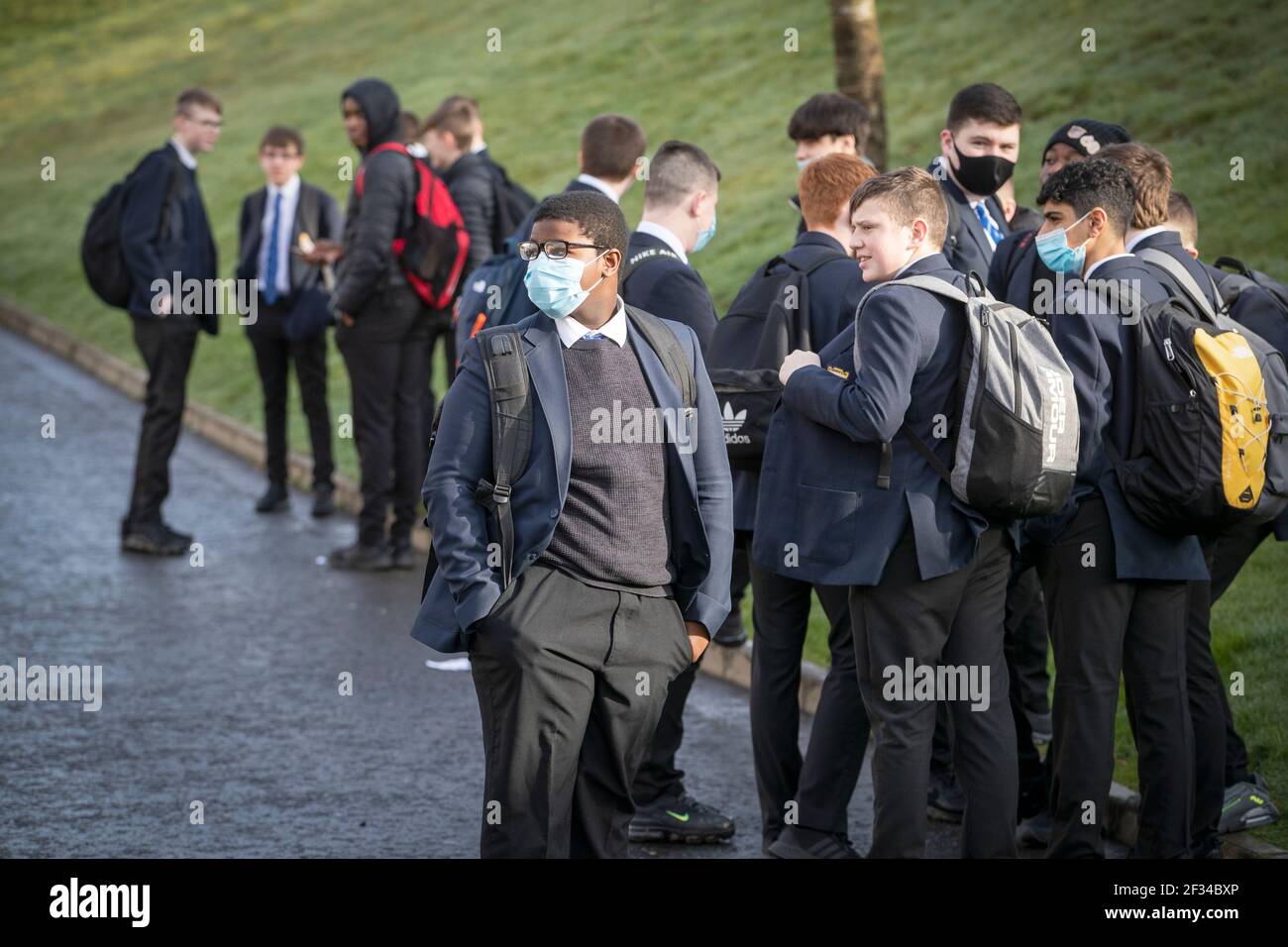 Gli studenti aspettano fuori prima delle lezioni che iniziano alla St Andrew's RC Secondary School di Glasgow, mentre un maggior numero di studenti torna a scuola in Scozia nell'ultima fase di blocco. Data immagine: Lunedì 15 marzo 2021. Foto Stock