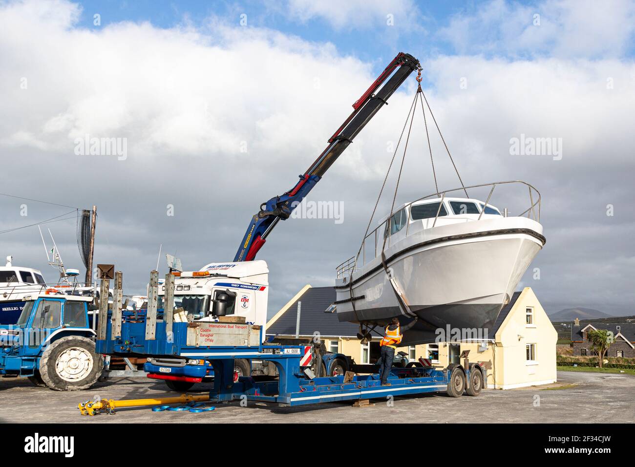 Barca che viene issata da Mobile Crane a Boatyard, County Kerry, Irlanda Foto Stock
