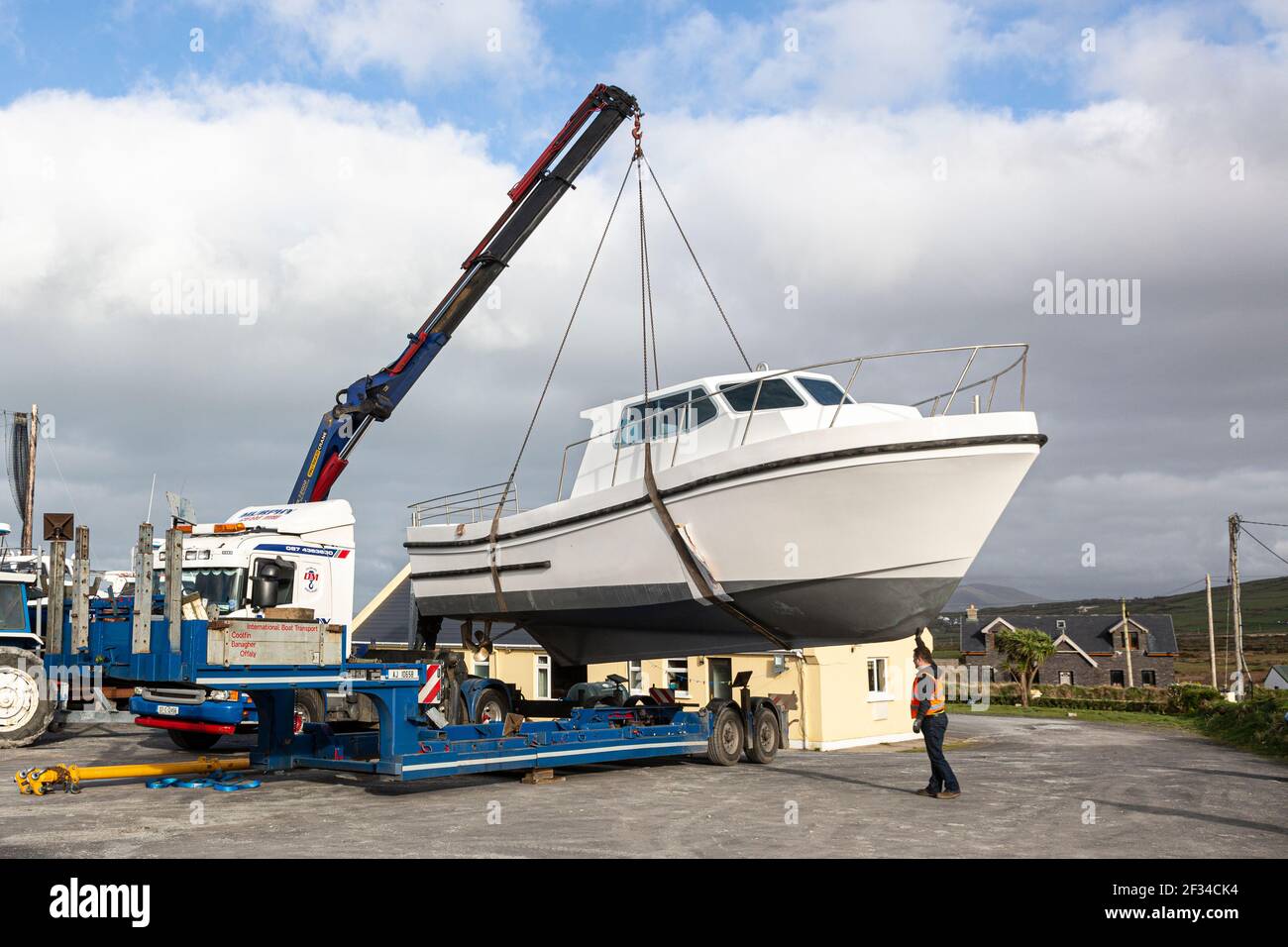 Barca che viene issata da Mobile Crane a Boatyard, County Kerry, Irlanda Foto Stock