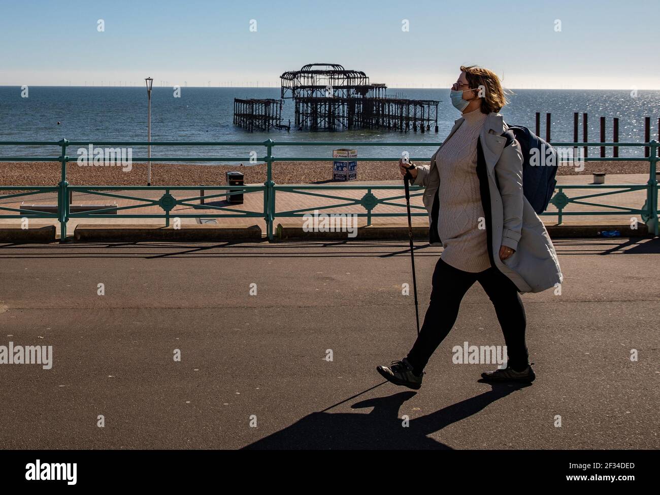 Un membro del pubblico che cammina intorno alla sfilata di Brighton mentre il tempo è soleggiato e chiaro questo fine settimana Foto Stock