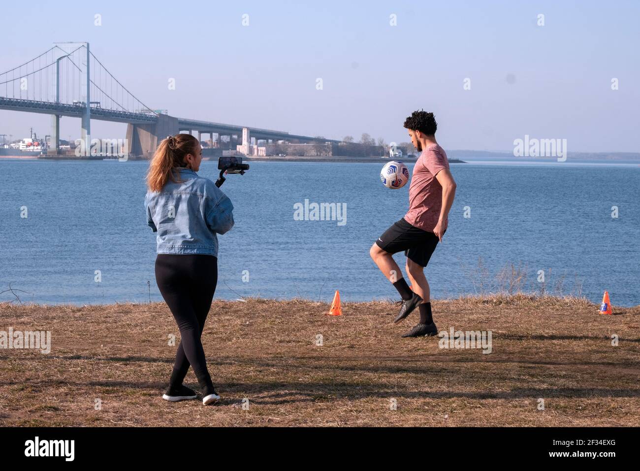 Un giocatore di calcio della varsity dell'università viene girato in una calda giornata invernale. A Little Bay Park a Whitestone, Queens, New York City. Foto Stock