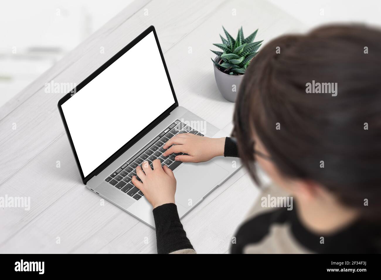 Donna lavora su computer portatile con schermo isolato per mockup, app o presentazione di siti web. Posizione isometrica, vista dalla spalla Foto Stock