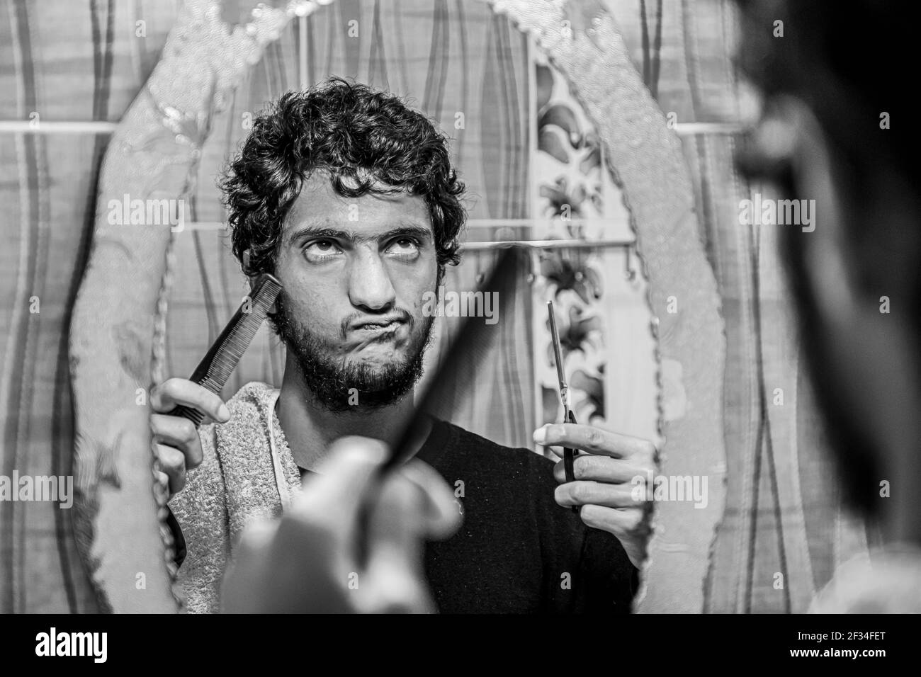 Uomo arabo musulmano che taglia i propri capelli da solo Foto Stock