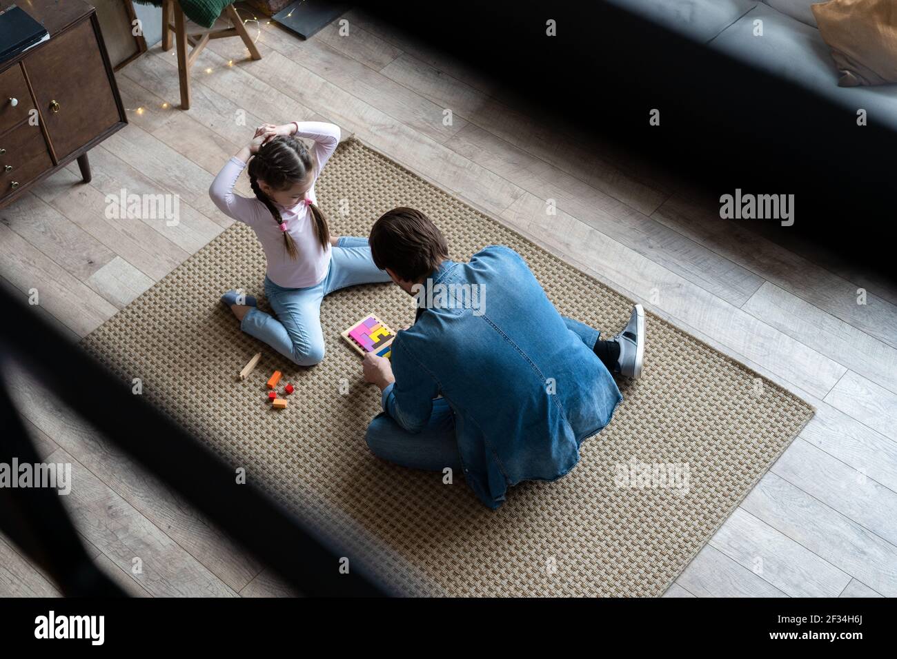 Vista dall'alto del giovane padre amorevole che giace sul pavimento con figlia hanno divertimento impegnato in attività divertente con mattoni da costruzione Foto Stock