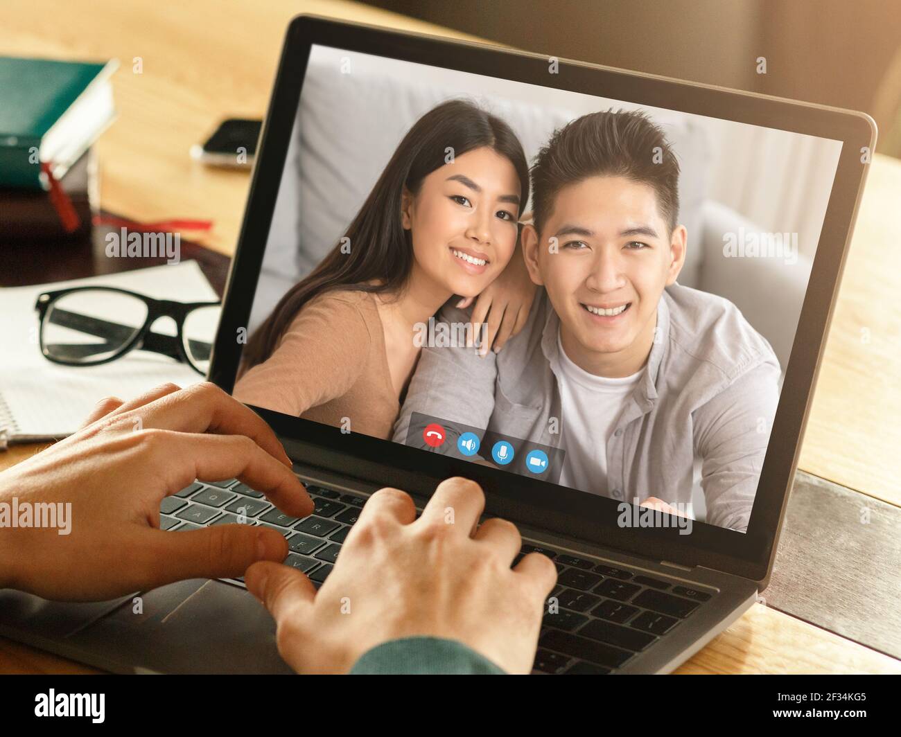 Uomo d'affari che comunica con una coppia che vive all'estero utilizzando il computer e. applicazione video Foto Stock