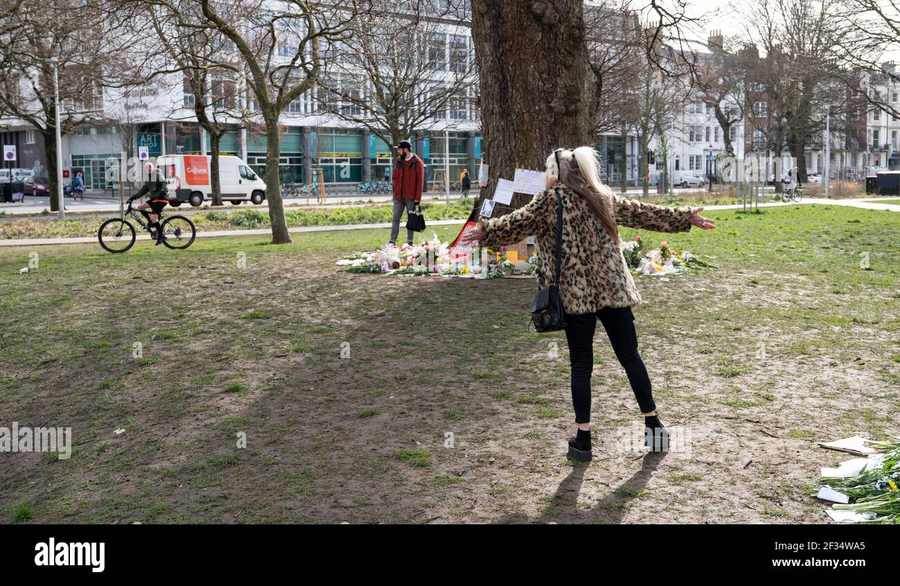 Brighton UK 15 marzo 2021 - UN uomo in bicicletta grida a persone che visitano i tributi floreali e i messaggi per la vittima dell'omicidio Sarah Everard ha lasciato a Valley Gardens a Brighton dove una veglia a lume di candela si è tenuta il sabato : Credit Simon Dack / Alamy Live News Foto Stock