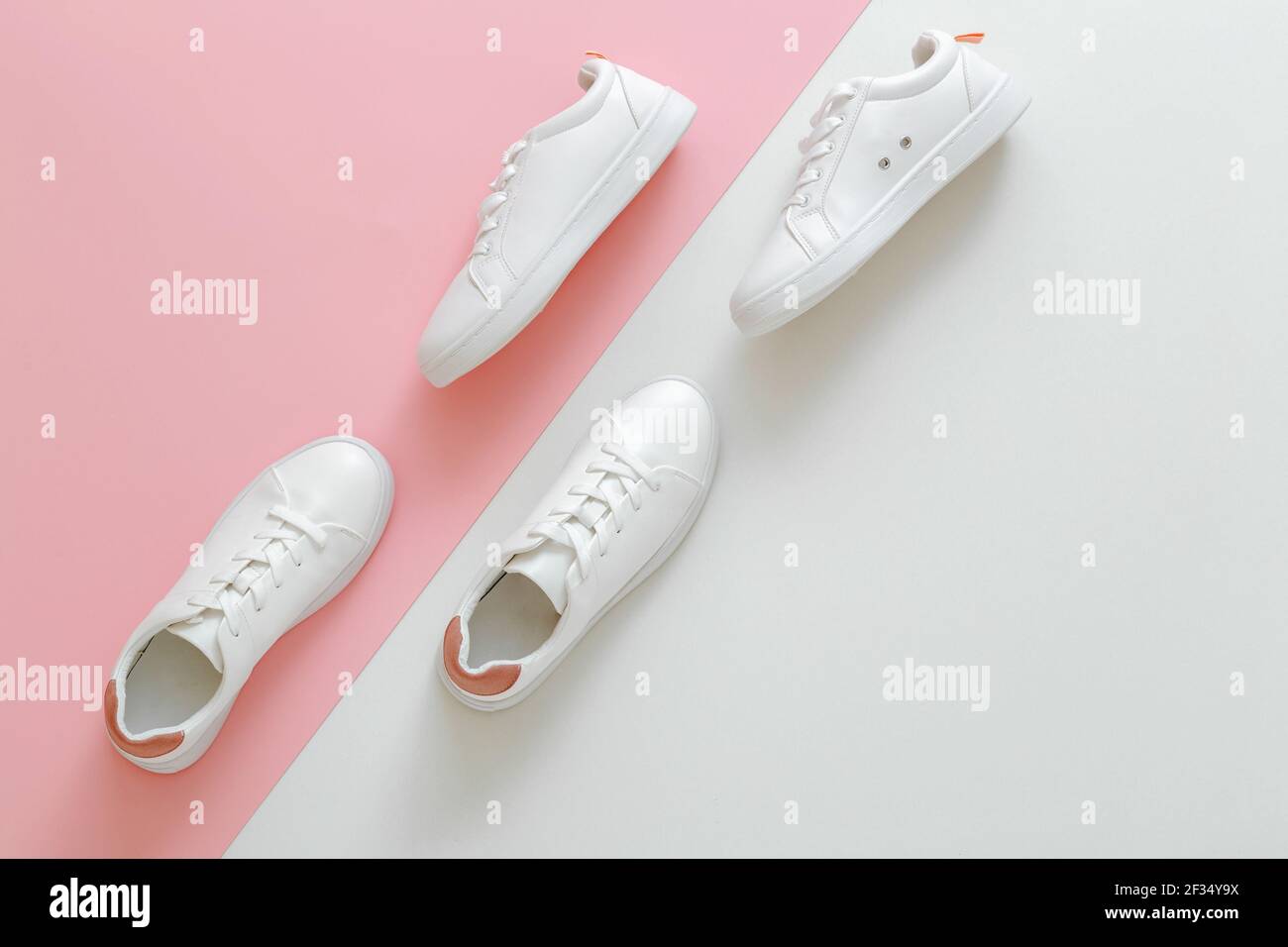 Sneakers bianche di colore rosa per uomo e donna. Scarpe in pelle bianca con lacci e spazio per la copia. Due scarpe da ginnastica eleganti con comoda spatolette Foto Stock
